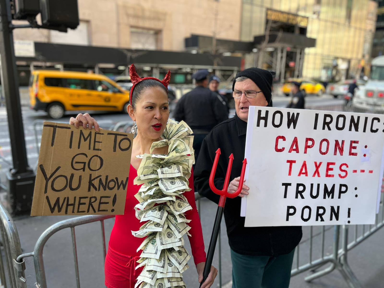 Manifestantes anti-Trump con pancartas que señalan la paradoja de que Al Capone hubiera sido procesado por evasión fiscal (pese a su largo historial criminal) y Trump, quien tiene otras investigaciones ante la justicia, por el caso relacionado a la actriz porno.