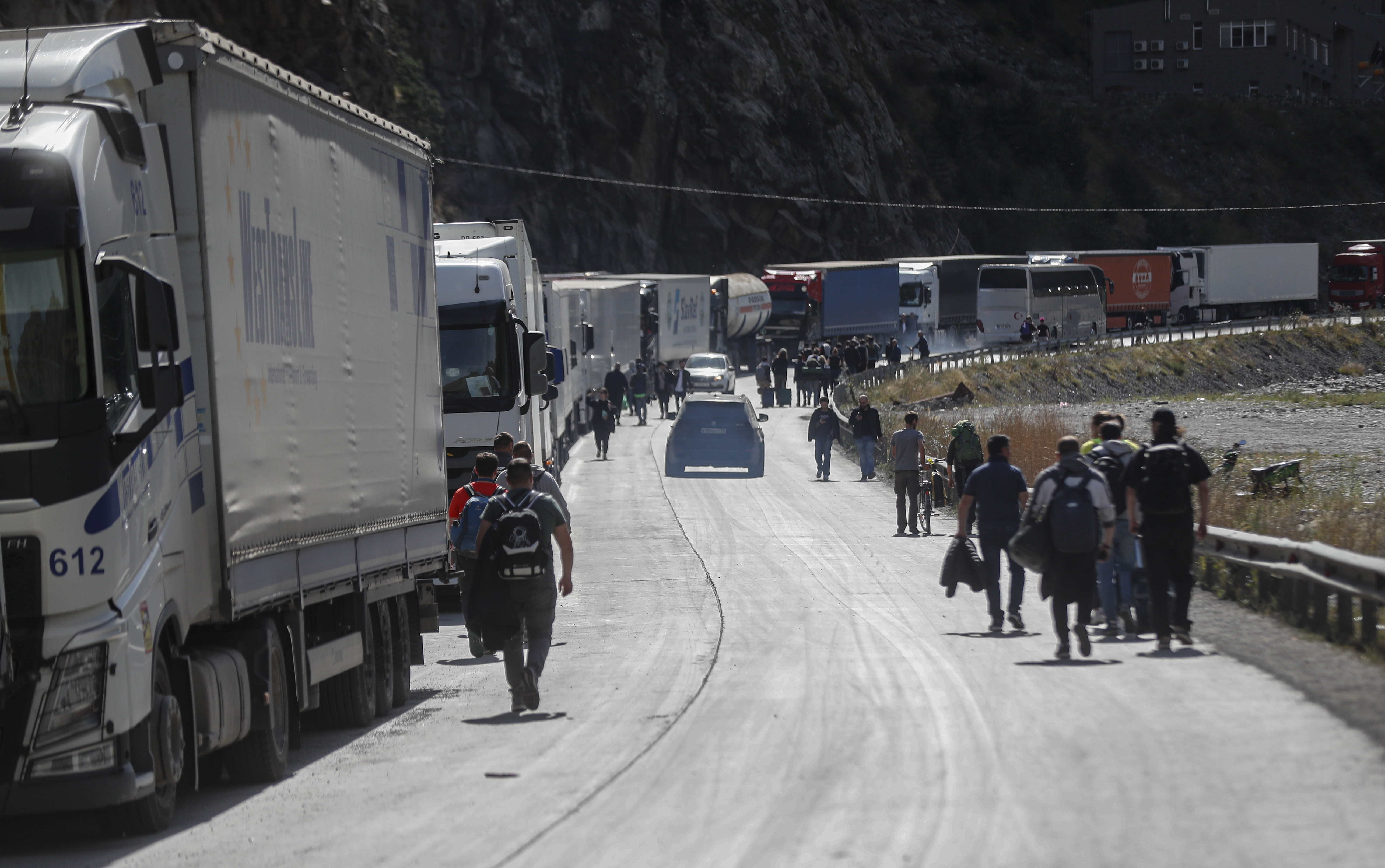 Verkhnii Lars (Georgia), 27/09/2022.- Russian men walk along a road after passing through customs at the Georgia-Russia border checkpoint of Verkhnii Lars, Georgia, 27 September 2022. Thousands of Russian men left Russia after Russian President Putin announced in a televised address to the nation on 21 September, that he signed a decree on partial mobilization in the Russian Federation due to the conflict in Ukraine. Russian Defense Minister Shoigu said that 300,000 people would be called up for service as part of the move. Georgian Interior Minister Vakhtang Gomelauri said on 27 September, that in recent days some 10,000 Russians have crossed the border with Georgia every day. On 24 February 2022 Russian troops entered the Ukrainian territory in what the Russian president declared a 'Special Military Operation', starting an armed conflict that has provoked destruction and a humanitarian crisis. (Rusia, Ucrania, Estados Unidos) EFE/EPA/ZURAB KURTSIKIDZE