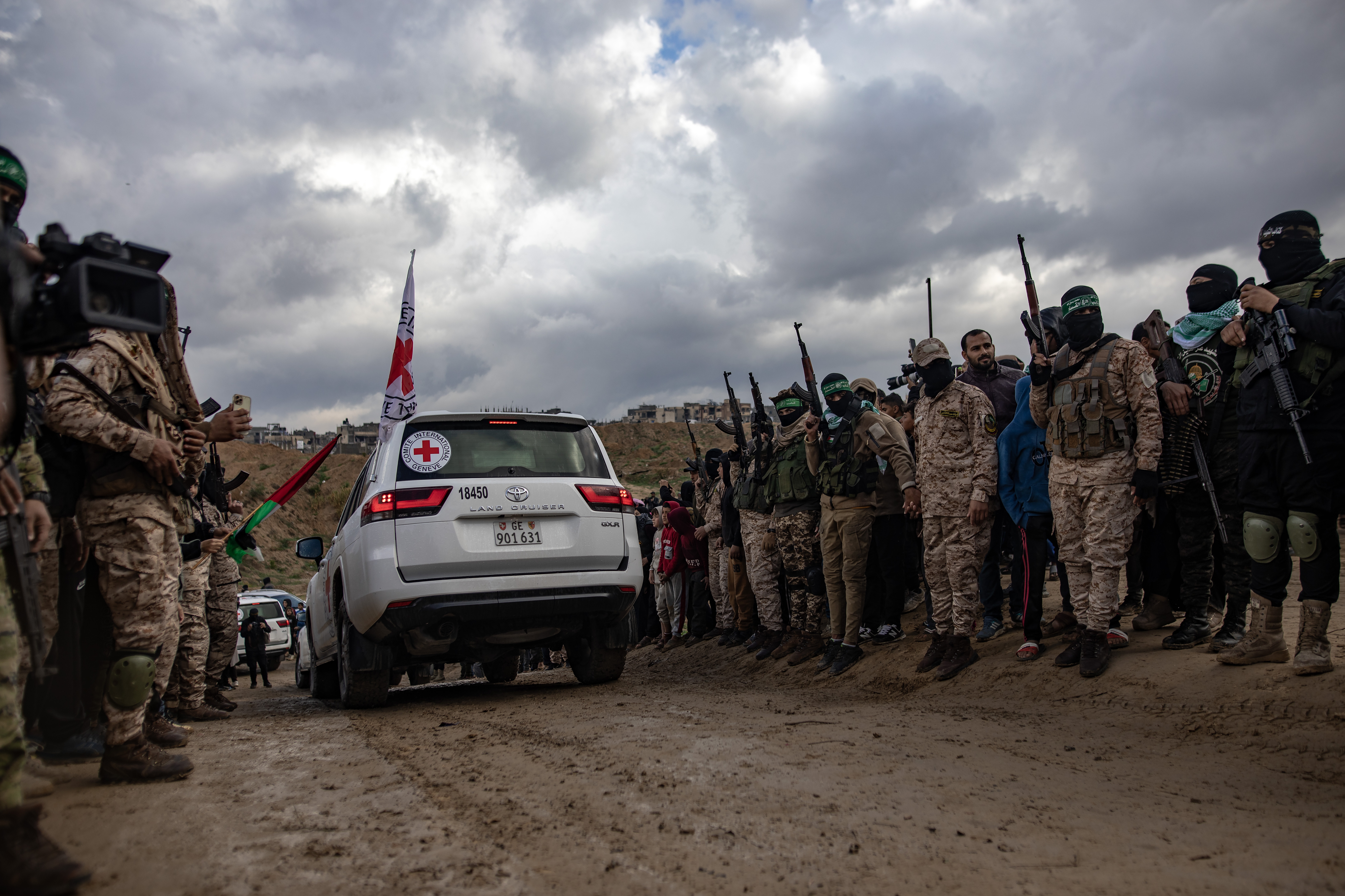 GAZA (-), 20/02/2025.- Palestinian civilians and fighters from Hamas's Izz ad-Din al-Qassam Brigades attend the handover of the bodies of four Israeli hostages to the Red Cross, in Khan Yunis, southern Gaza Strip, Thursday, 20 February, 2025. Hamas was set to hand over the bodies of four Israeli captives, including that of youngest hostage Kfir Bibas, as part of the ongoing Gaza ceasefire deal. Hamas said in November 2023 that the two Bibas boys and their mother had been killed in an Israeli airstrike on Gaza. EFE/EPA/HAITHAM IMAD