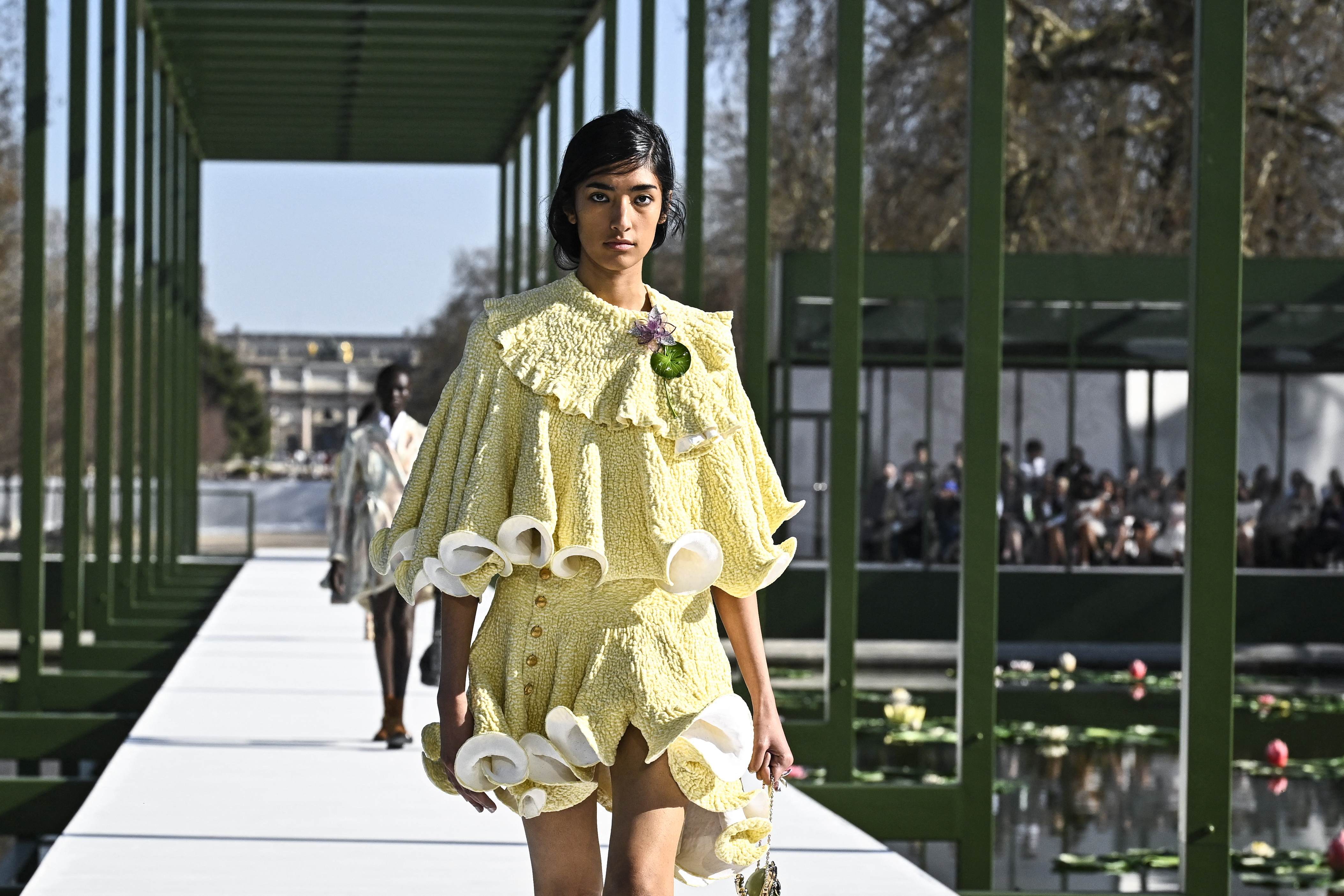Bajo un sol radiante, las modelos de Dior desfilaron en una estructura acristalada alrededor de un estanque con nenúfares en el jardín de las Tullerías. / Julien de Rosa / AFP