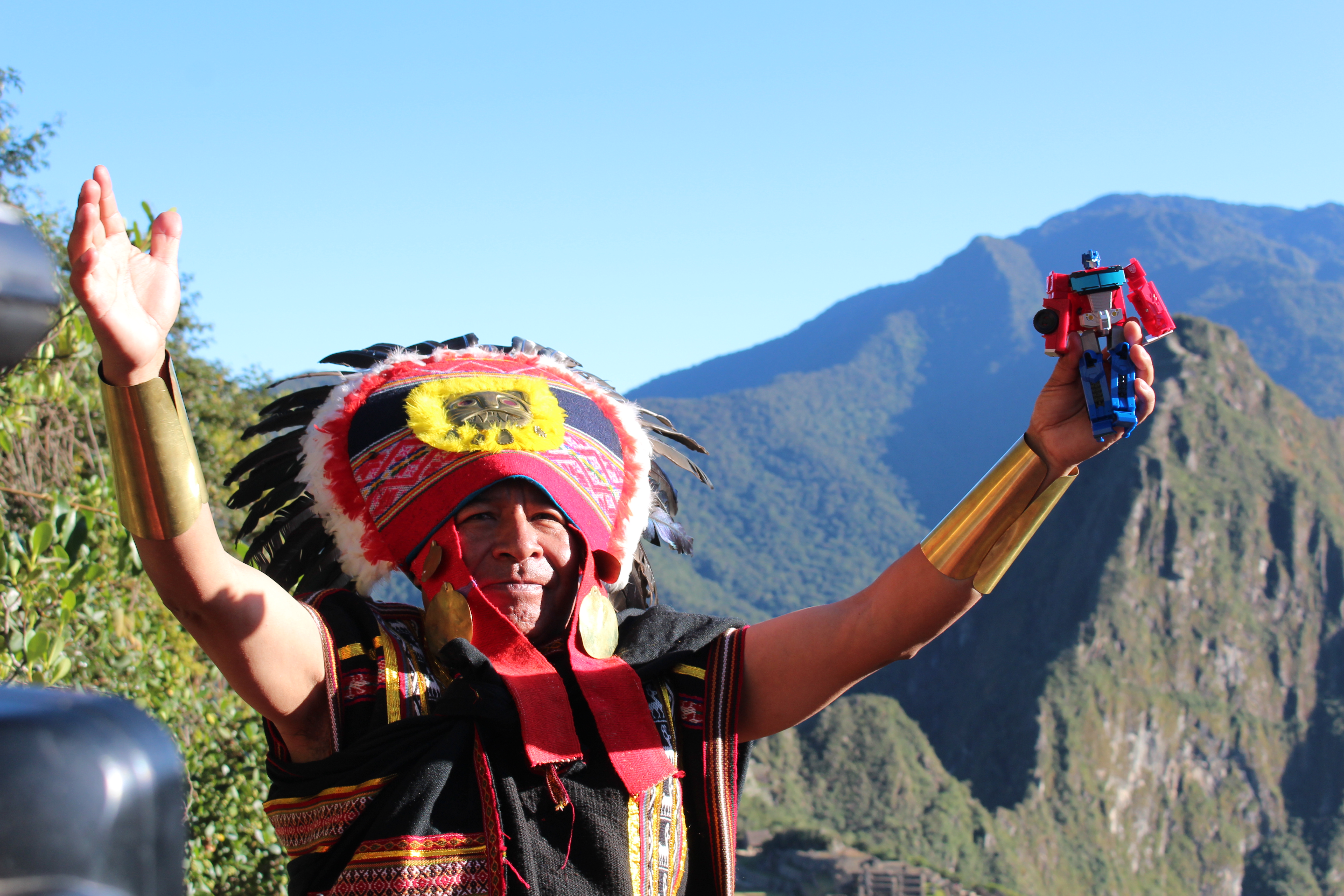 -FOTODELDÍA- AME4078. MACHU PICHU (PERÚ), 04/06/2023.- Un indígena que sostiene la imagen de un "Transformer" participa en una ceremonia de ofrenda a la tierra hoy, en la ciudadela prehispánica de Machu Picchu (Perú). El misticismo de Cuzco y de Machu Picchu son el escenario de la nueva entrega de la saga de "Transformers, el despertar de las bestias", un film donde la potencia de épicas batallas entre robots se mezcla con la cultura andina de Perú y los paisajes que dejan sin aliento. EFE/ Paula Bayarte