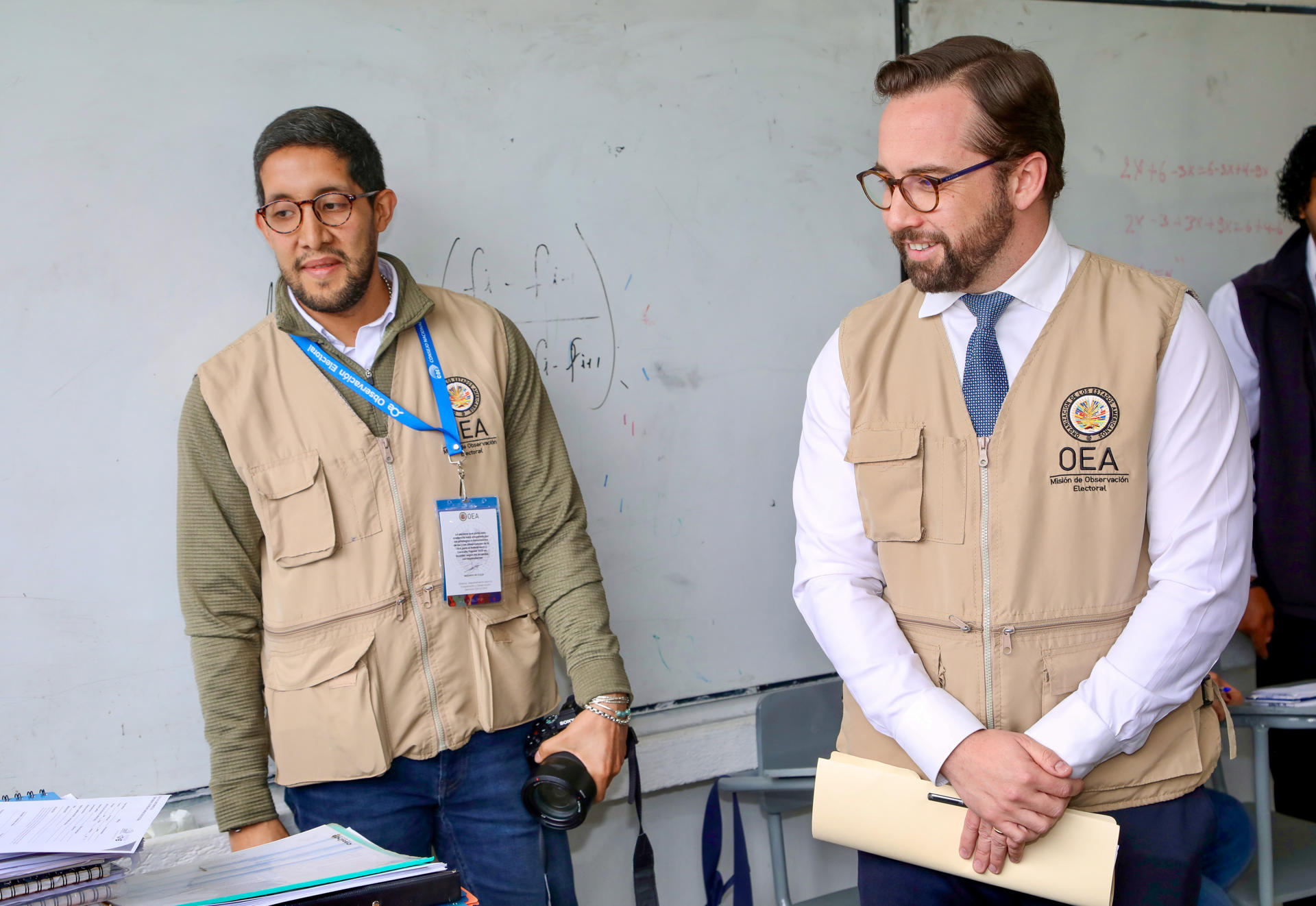 AME9745. QUITO (ECUADOR), 16/11/2025.- El jefe de misión de la OEA, Nicolás Albertoni (d), realiza un recorrido por un colegio para verificar que el proceso de referéndum y consulta popular se desarrolle con normalidad, este domingo, en Quito (Ecuador). EFE/Gianna Benalcázar
