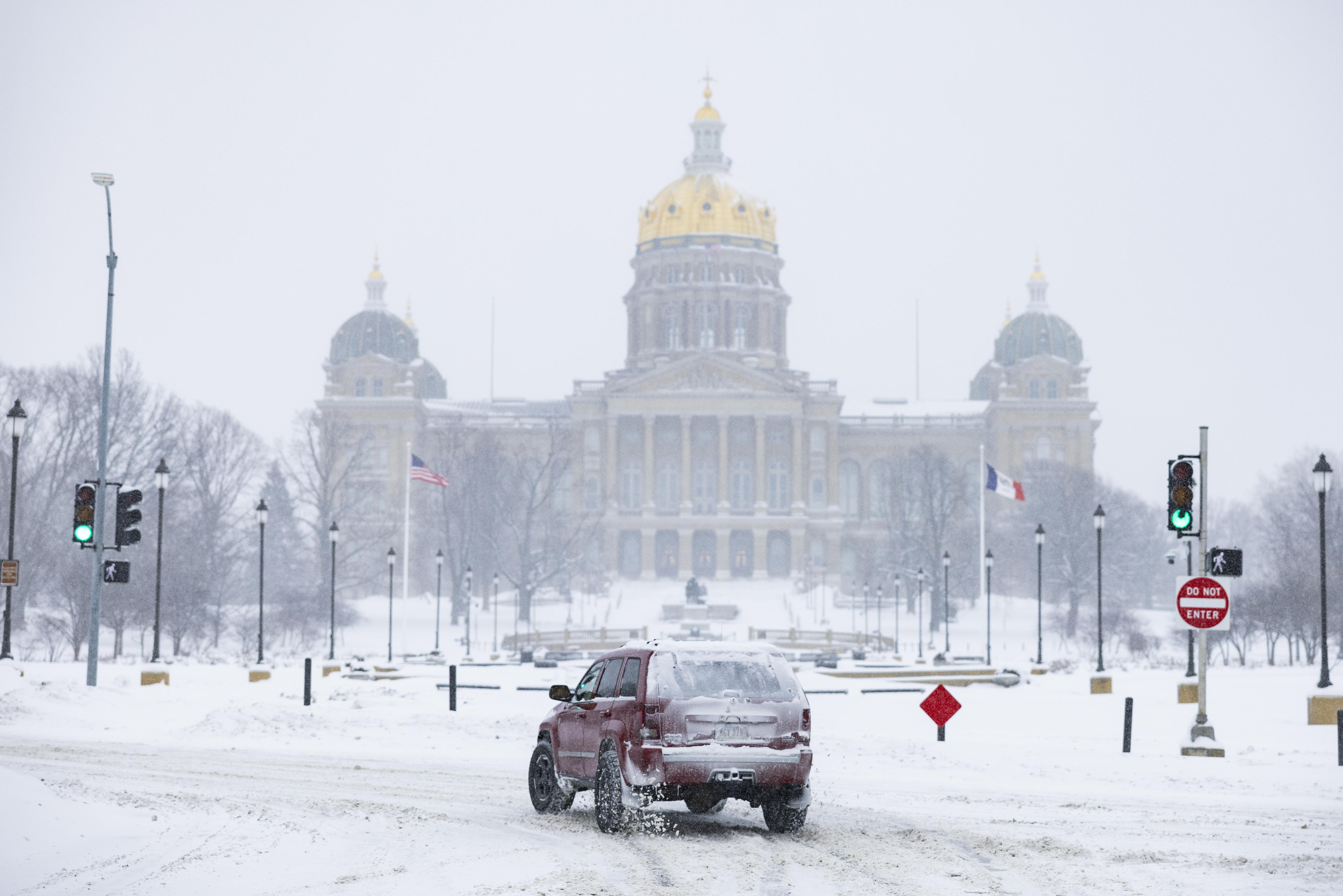 Des Moines (United States), 12/01/2024.- A car drives on a road covered with snow backdropped by the Iowa State Capitol as a blizzard strikes downtown Des Moines, Iowa, USA, 12 January 2024. Candidates who would normally be criss-crossing Iowa in the final days before its first-in-the-nation caucus on 15 January are cancelling many of their events today, as winter weather is creating unsafe travel conditions. EFE/EPA/JIM LO SCALZO