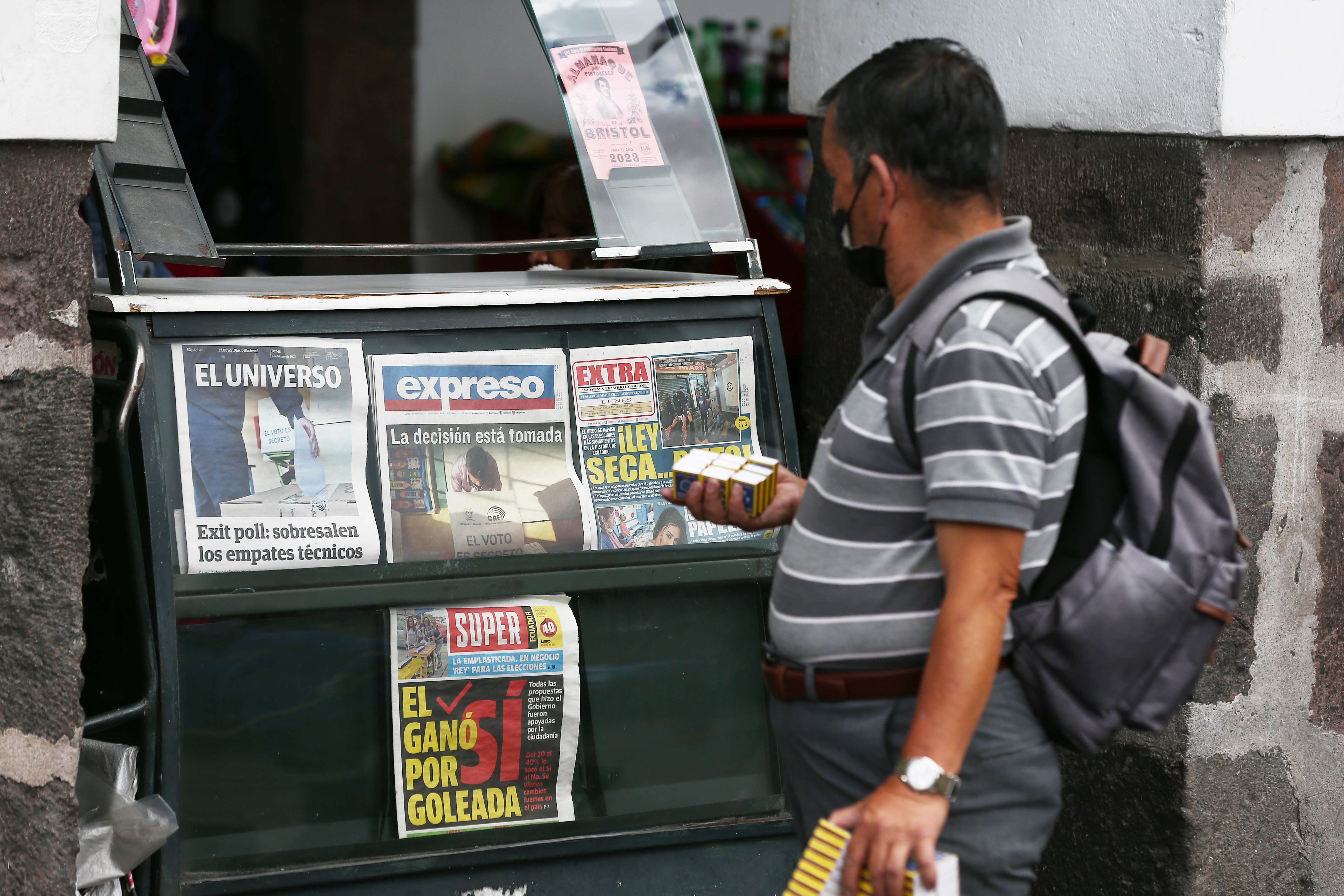 AME2167. QUITO (ECUADOR), 06/02/2023.-Un hombre observa las portadas de los periódicos tras la jornada de votaciones de este domingo al referéndum que pretendía reformar la Constitución en materia de seguridad, democracia, instituciones y medioambiente, hoy, en Quito (Ecuador). La tendencia por el "No" predominaba este lunes en el lento avance del escrutinio del referéndum planteado por el presidente ecuatoriano Guillermo Lasso, que pretendía reformar la Constitución en materia de seguridad, democracia, instituciones y medioambiente. Con un 46,71 % de las actas procesadas, el "No" va por delante con un 53,8 % frente al 46,15 % del "Sí" en la primera pregunta con la que Lasso buscaba apoyo para facilitar la extradición de ecuatorianos por hayan cometidos delitos vinculados al crimen organizado trasnacional. EFE/ José Jácome