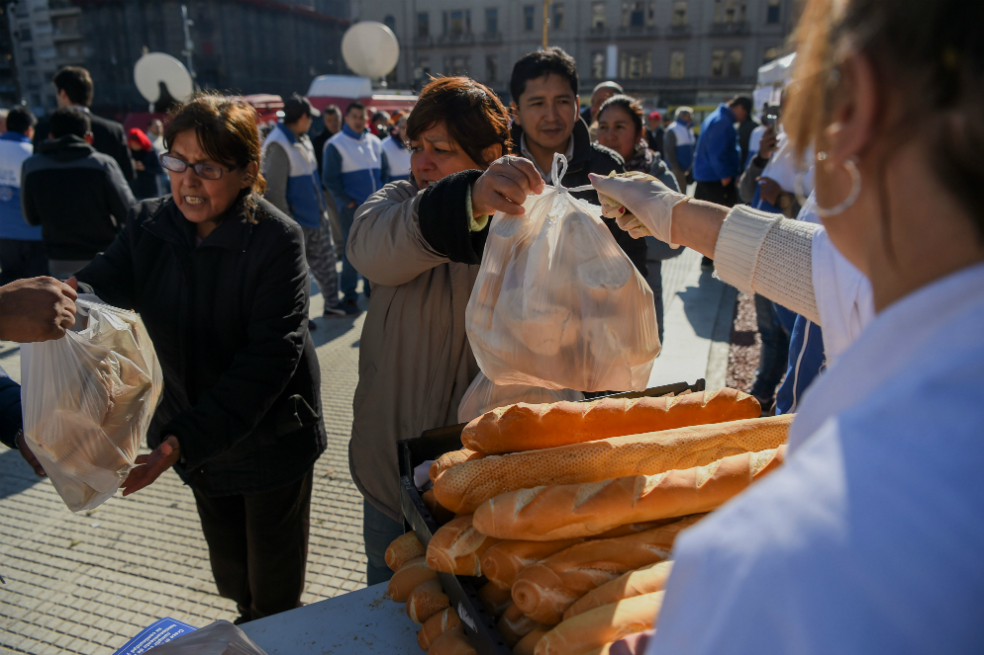 Panaderos argentinos entregan pan en frente del Congreso Nacional en Buenos Aires, Argentina, para protestar contra los aumentos de los precios de la harina.