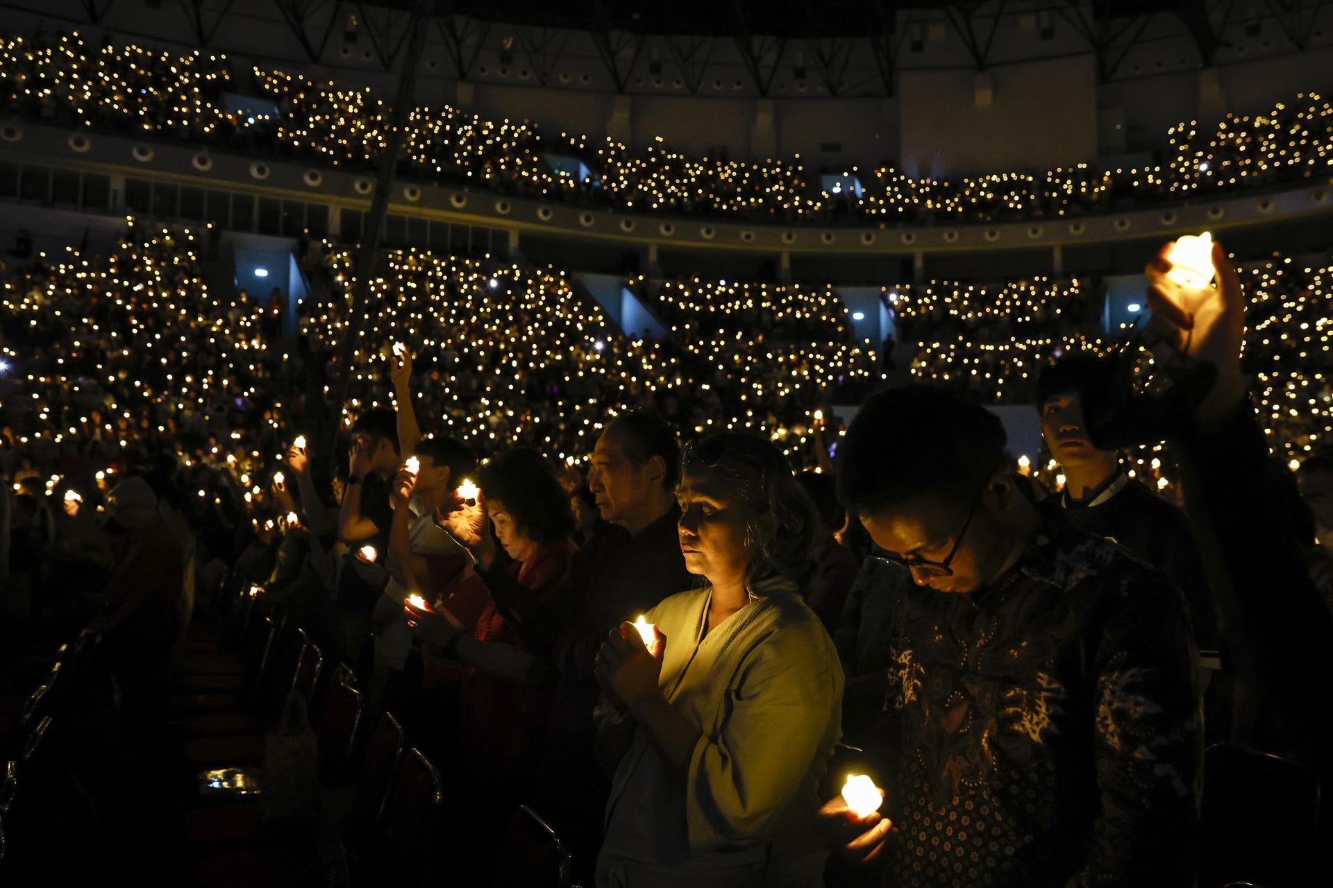 JAKARTA (Indonesia), 24/12/2025.- Worshippers hold LED lights during a candlelight service on Christmas Eve at the Indonesia Arena in Jakarta, Indonesia, 24 December 2025. Although the majority of Indonesians are Muslim, Christmas is widely observed across the country, with many non-Christians celebrating it as a secular holiday. EFE/EPA/MAST IRHAM