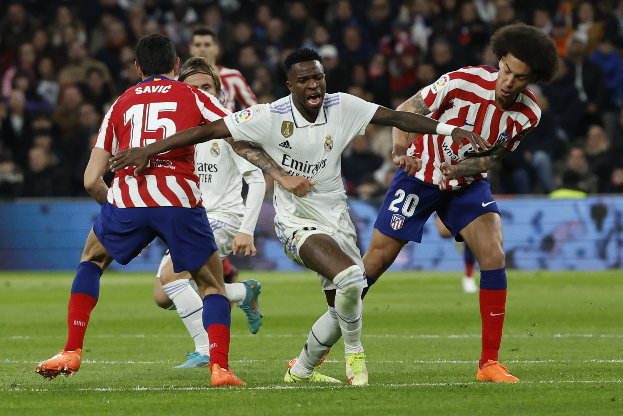 MADRID 25/02/2023.- El delantero brasileño del Real Madrid Vinicius Jr. (c) lucha con Savic (i) y con Axel Witsel, ambos del Atlético de Madrid, durante el partido de la jornada 23 de LaLiga que enfrenta este sábado al Real Madrid y al Atlético de Madrid en el estadio Santiago Bernabéu, en Madrid. EFE/Juanjo Martín