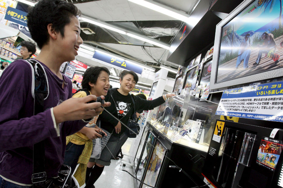 Dos niños japoneses juegan Play Station 3 en una tienda Sony de Tokio
