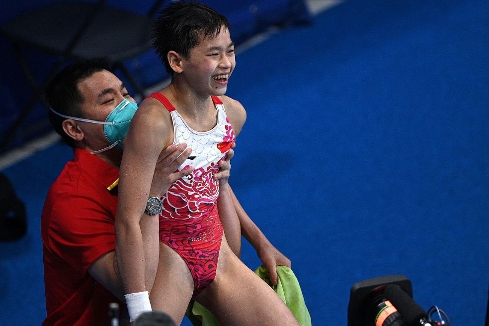 Hongchan Quan, de solo 14 años, fue campeona con registro perfecto de los clavados de 10 metros. Con dos saltos de 10 puntos de cinco intentos, la clavadista china hizo historia. Tras ganar, quedó registrada para la historia la imagen de su entrenador alzándola en brazos.