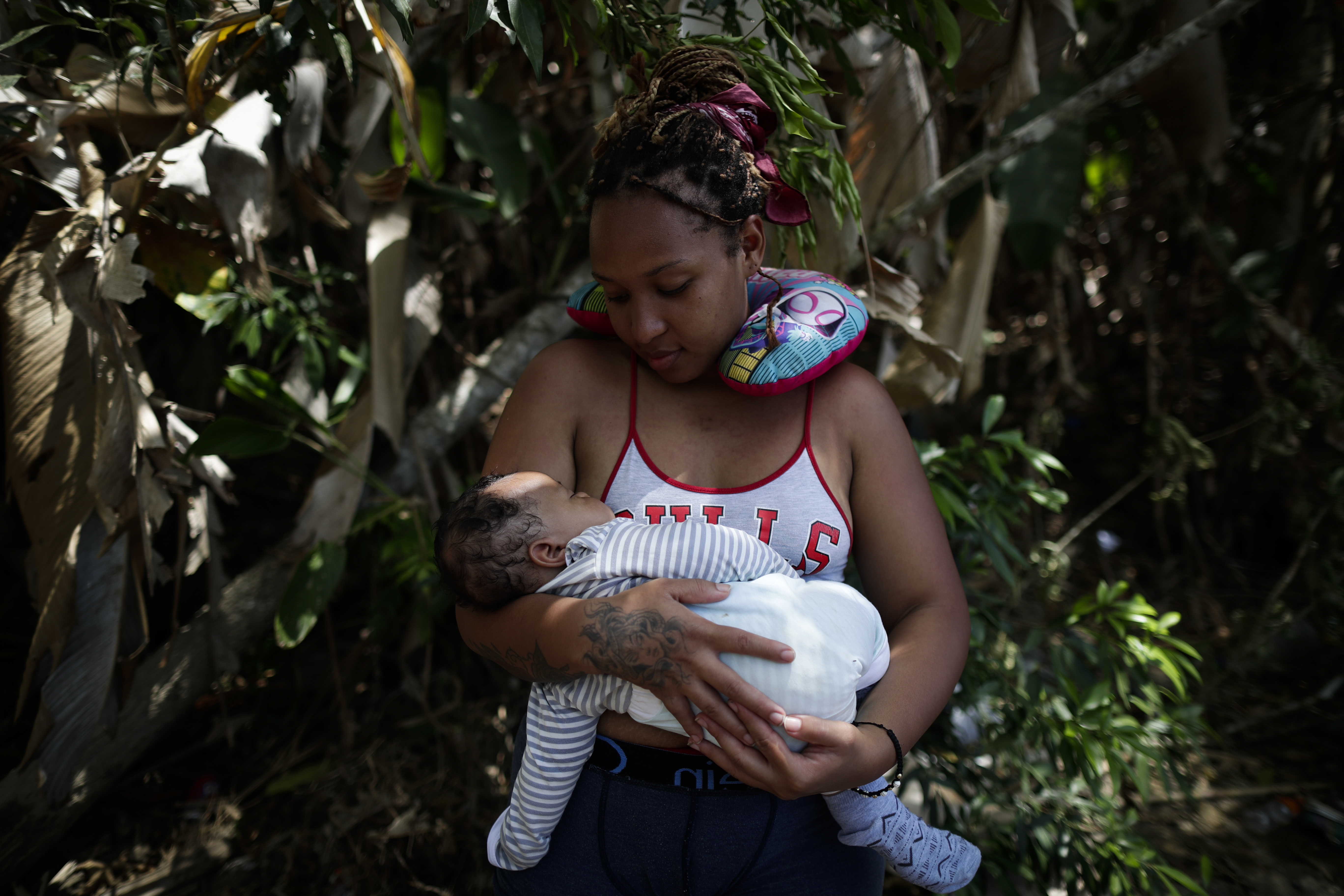 -FOTOGALERÍA- AME4250. BAJO CHIQUITO (PANAMÁ), 21/03/2023.- Ana Teresa Rodríguez, una venezolana de 26 años, carga a su hijo Aquiles Cedeño de 2 meses mientras esperan para ser trasladados en canoa desde la Quebrada León hasta a la comunidad de Bajo Chiquito, el 10 de marzo de 2023, en Darién (Panamá). "Guerreros", repiten las madres, hijos guerreros que han aguantado largas caminatas, hambre, sed, el calor, picaduras de insectos, superar ríos y cerros, para sobrevivir a la selva del Darién en su ruta hacia Estados Unidos. La venezolana Ana Rodríguez también está con su bebé en brazos, que duerme. Durante la selva lo cargó "un ratico" ella, otro su esposo, un amigo. "Hay gente que te ayuda, como hay gente que no tiene fuerza para ayudarte". "Aquí hay mujeres embarazadas, niños, pero no es fácil, lo que se vive adentro no es fácil. Nada más cuando cae la noche, la expectativa de que tus hijos no se enfermen, porque se mojan. Que uno no se enferme, lo que uno ve allá adentro, carpas cerradas con gente adentro muerta. Se ven muchas cosas: travesía, hueco, río hondo, gente ahogándose. Es algo, una experiencia para toda la vida, por una mejoría, porque es la única manera", afirma a EFE Rodríguez. EFE/ Bienvenido Velasco