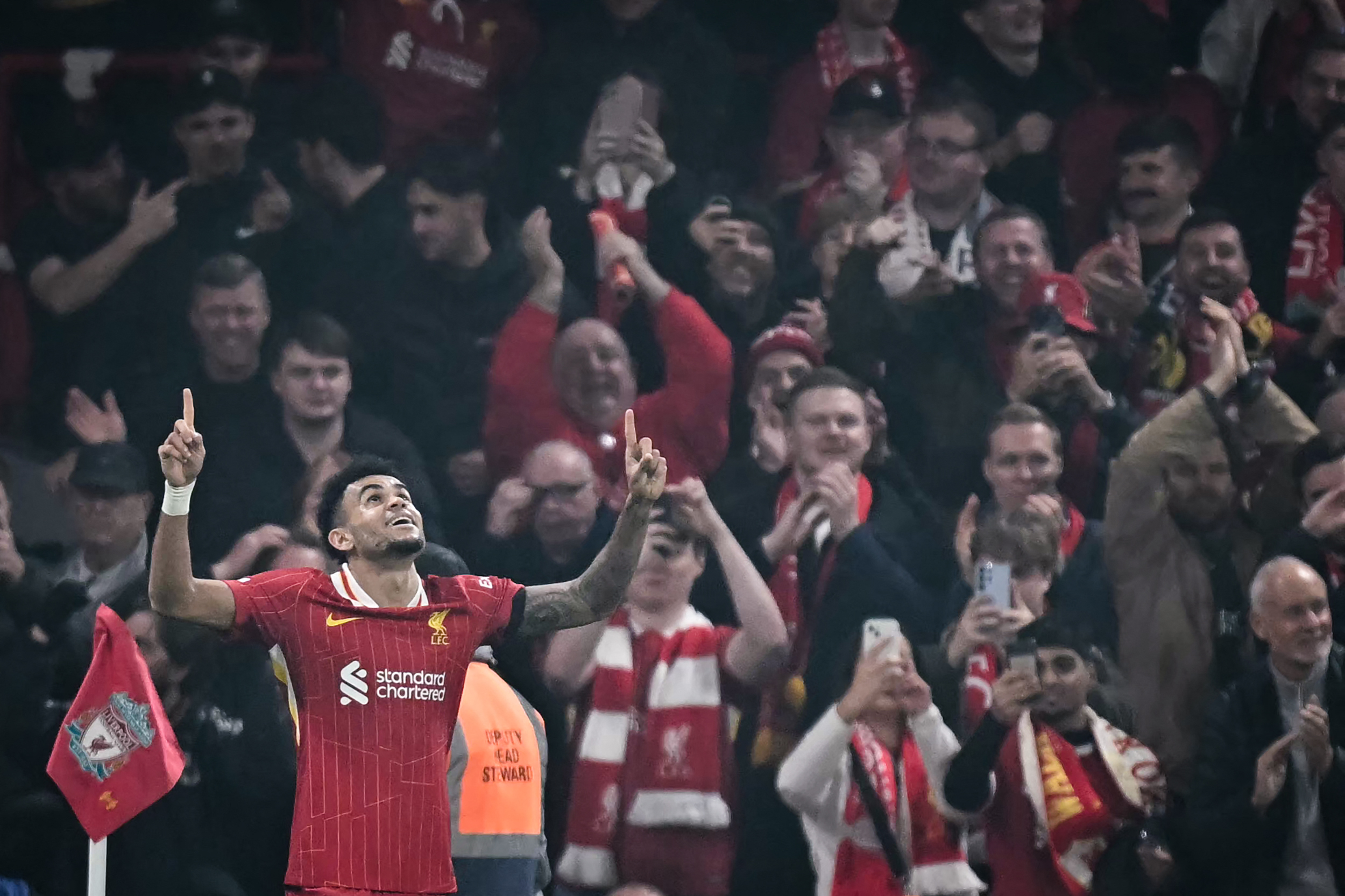 Liverpool's Colombian midfielder #07 Luis Diaz celebrates after scoring his team fourth goal during the UEFA Champions League football match between Liverpool and Bayer Leverkusen at Anfield stadium, in Liverpool, north west England, on November 5, 2024.