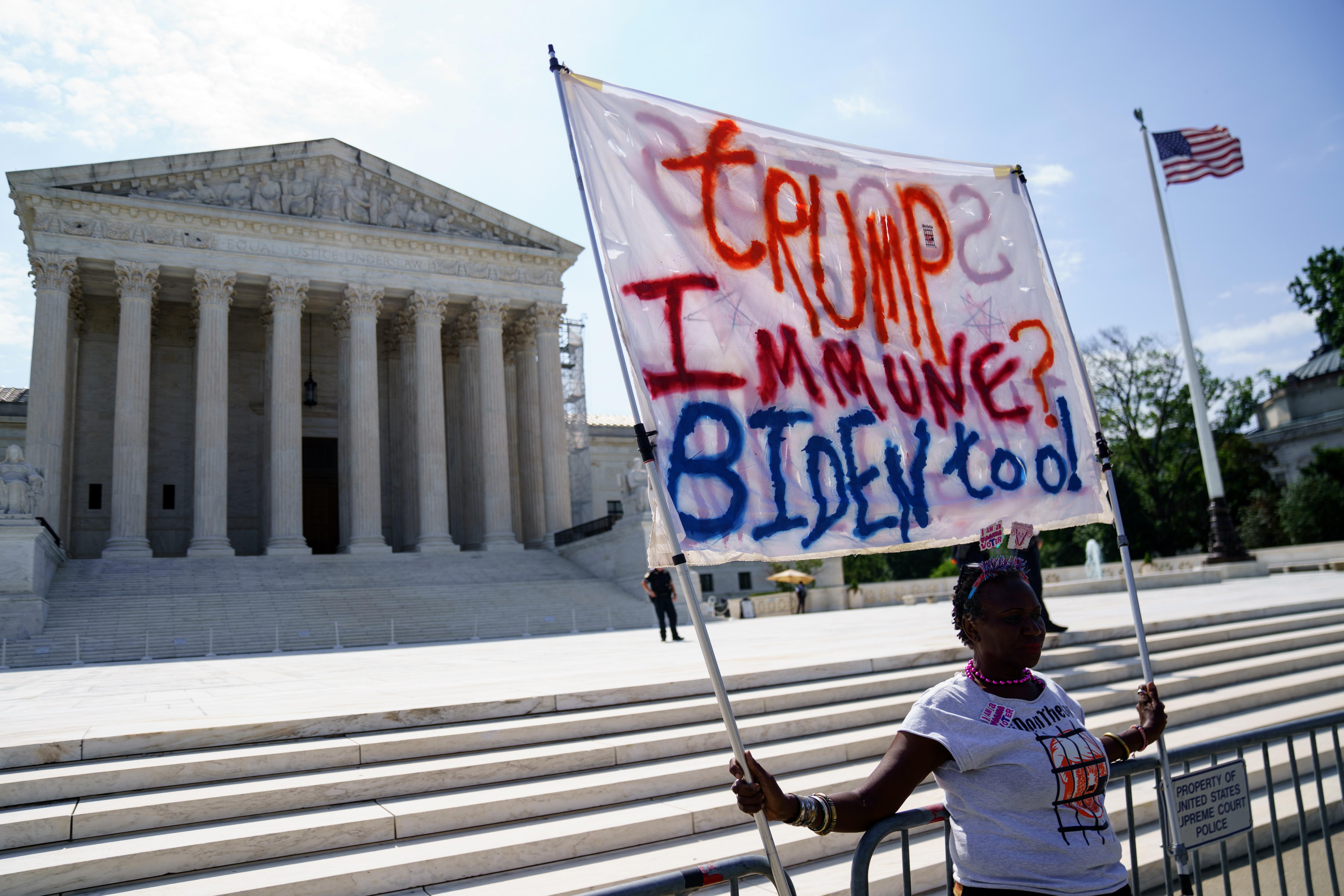 Washington (United States), 28/06/2024.- A protester carries a banner outside the US Supreme Court, in Washington DC, USA, 28 June 2024. The Court issued a range of opinions including narrowing the statute that prosecutors have used in the cases of defendants who particpated in the January 6 Capitol attack. (Protestas) EFE/EPA/WILL OLIVER