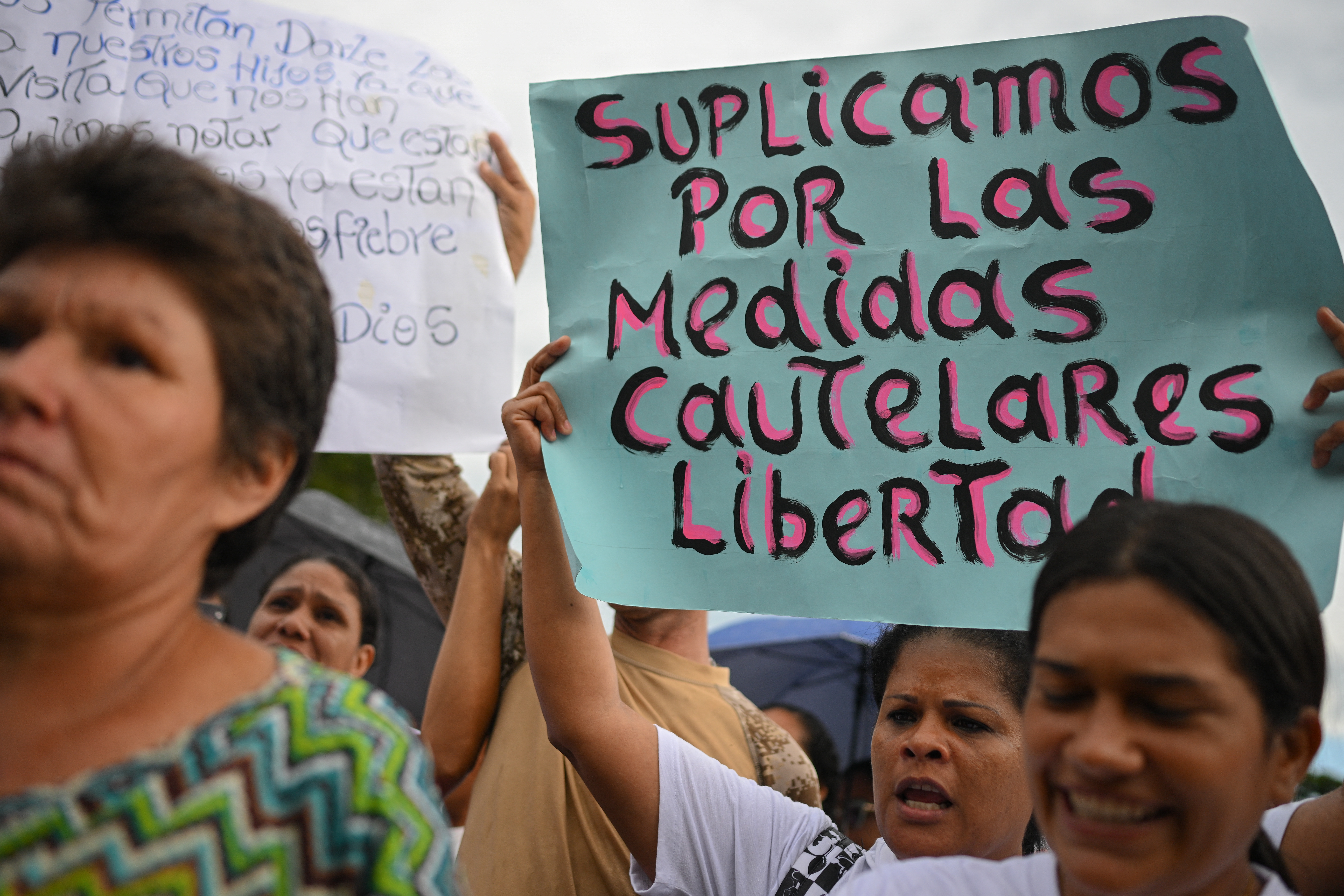 A woman holds a sign demanding freedom for people arrested during the protests following the disputed July 31 presidential election, outside the Tocuyito prison in Tocuyito, Carabobo State, Venezuela on October 16, 2024. (Photo by Federico PARRA / AFP)