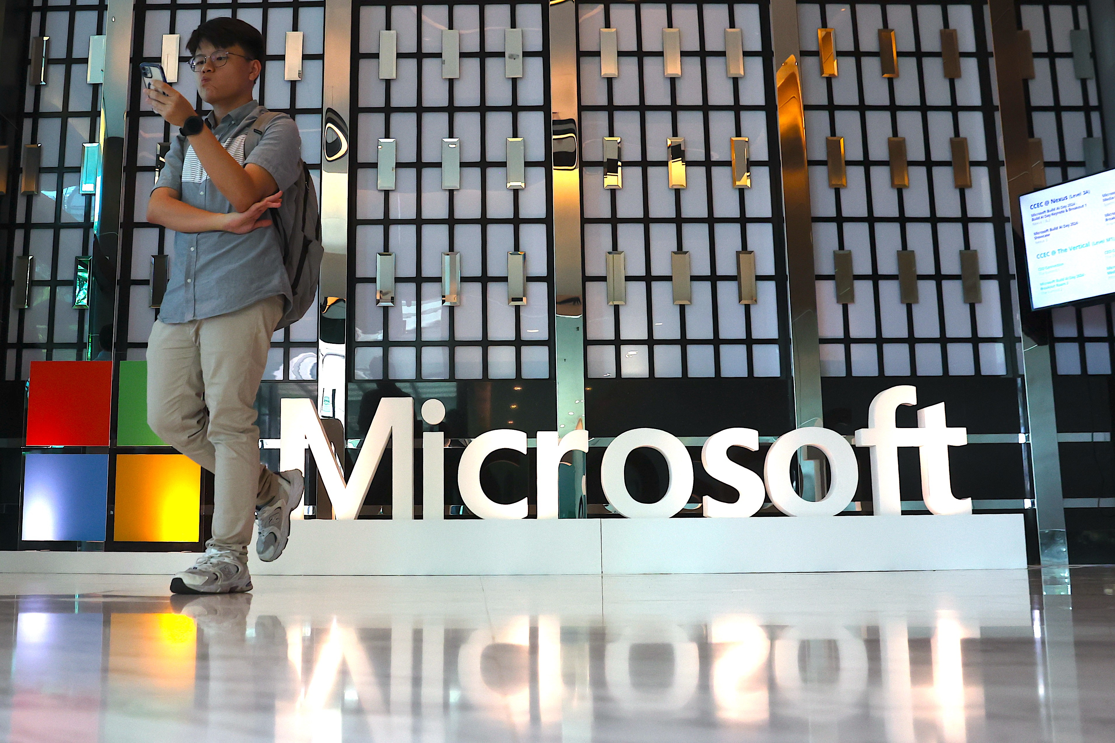 EA4187. BOGOTÁ (COLOMBIA), 28/11/2024.- Fotografía de archivo fechada el 02 de mayo de 2024 que muestra una persona caminando cerca del logo de Microsoft durante el evento Microsoft Build: AI Day, en Kuala Lumpur (Malasia). 'También tú, Microsoft' es uno de los clics tecnológicos de la semana. Si en Microsoft andaban felices por el posible desmembramiento al que pueda ser sometido Google, pues se les puede ir borrando esa sonrisa. ¿Por qué? Porque la Comisión Federal de Comercio de Estados Unidos (FTC) les abrió una investigación antimonopolio. EFE/EPA/FAZRY ISMAIL /ARCHIVO