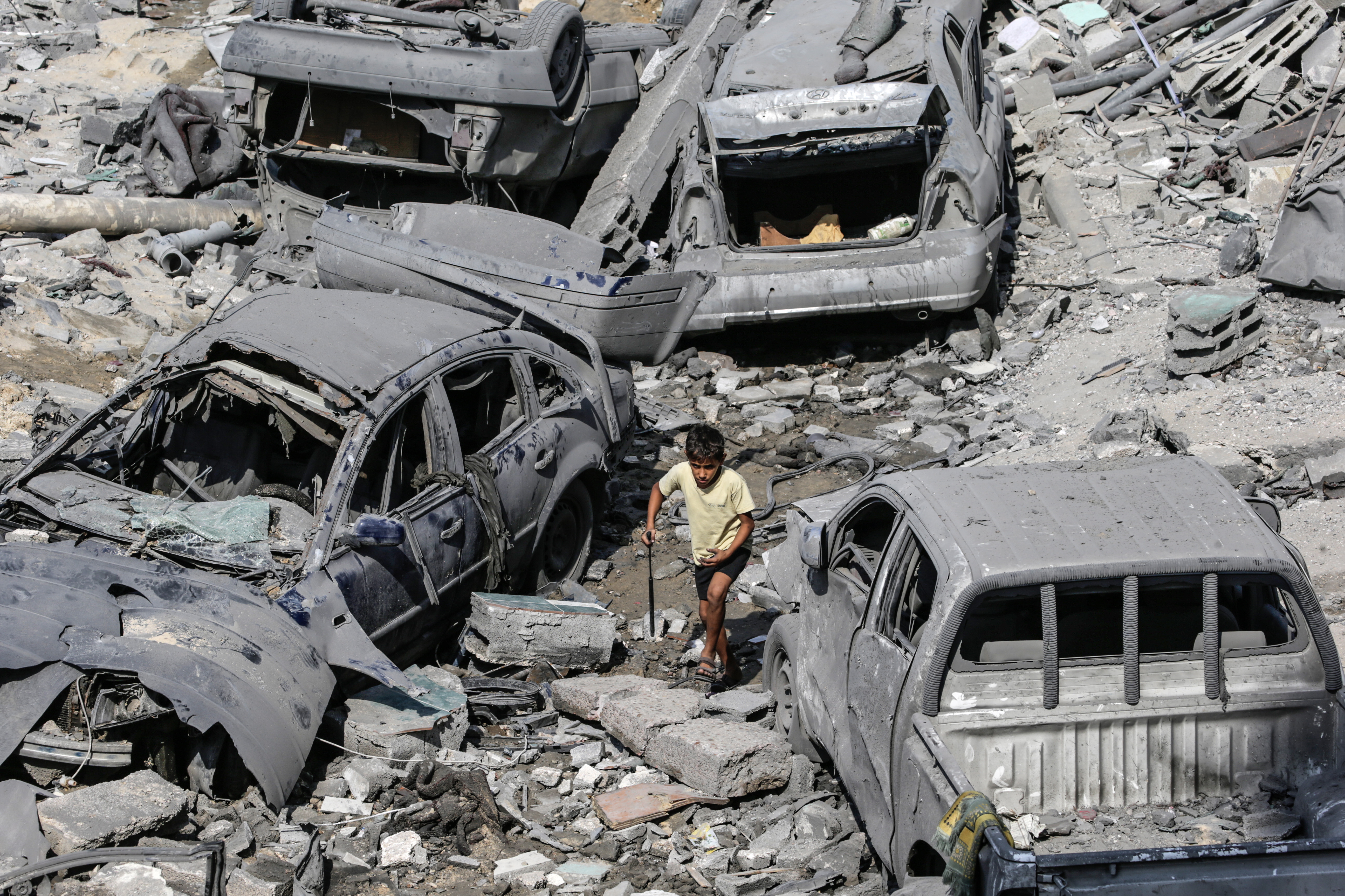 Gaza, 09/10/2023.- Un niño palestino pasa junto a coches dañados en medio de los escombros de una zona destruida tras los ataques aéreos israelíes en la ciudad de Gaza, este lunes. El ejército israelí anunció el 9 de octubre que durante la noche se lanzaron más de 500 ataques contra objetivos en toda la Franja de Gaza. Los funcionarios palestinos dijeron que casi 500 personas murieron y más de 2.700 resultaron heridas después de que Israel lanzara ataques aéreos y ataques de represalia. EFE/MOHAMMED SABER
