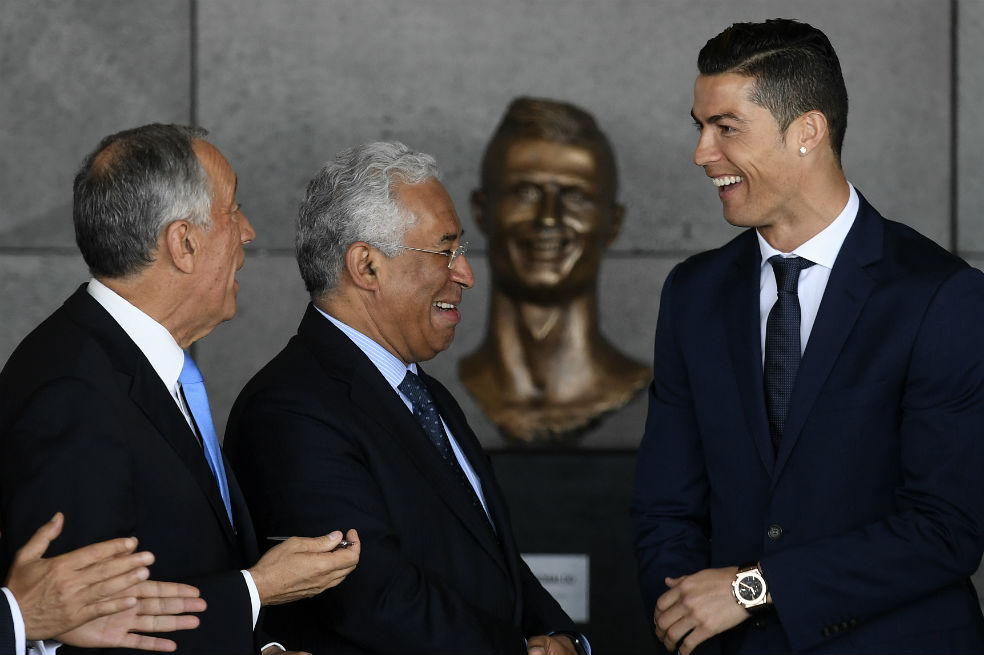 El futbolista portugués (derecha), en compañía del primer ministro Antonio Costa (centro) y el presidente Marcelo Rebelo de Sousa (izquierda) durante la ceremonia en el aeropuerto de Madeira en Funchal. /AFP