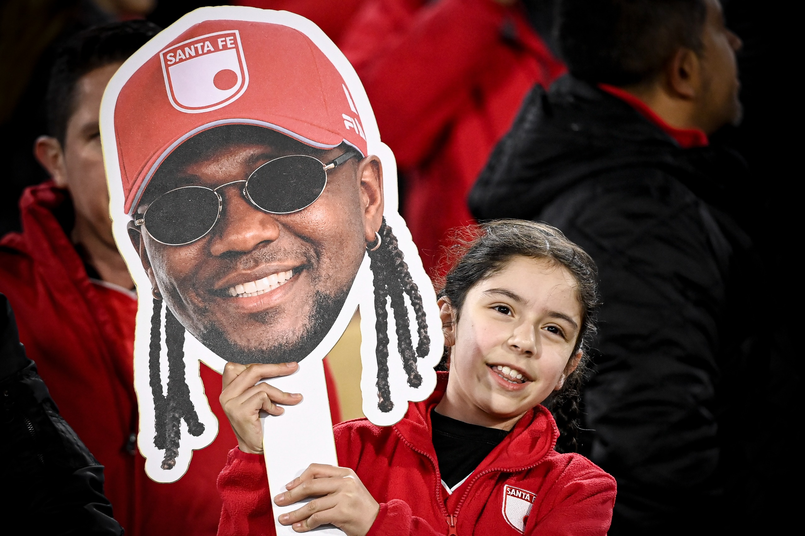 Pequeña hincha de Santa Fe con un cartel de Hugo Rodallega en el estadio Nemesio Camacho El Campín de Bogotá durante el partido contra Caracas en Copa Sudamericana.