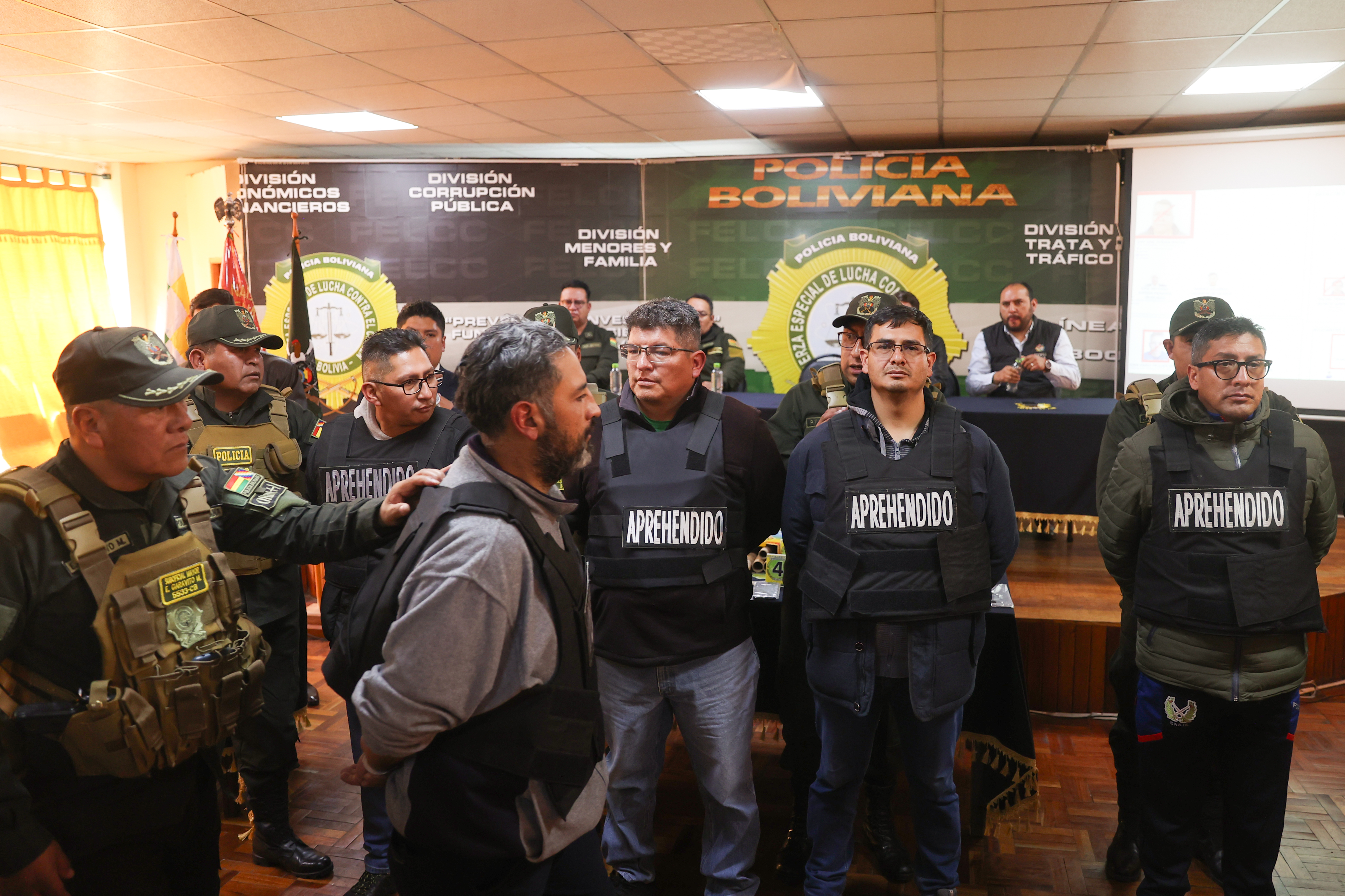 AME7245. LA PAZ (BOLIVIA), 27/06/2024.- Un integrante de la Policía de Bolivia escolta a militares detenidos luego del intento de golpe de estado en rueda de prensa este jueves, en La Paz (Bolivia). El ministro de Gobierno de Bolivia Eduardo Del Castillo presentó hoy en La Paz, en las dependencias de la Fuerza Especial de Lucha Contra el Crimen, a exmilitares en reserva y militares activos que fueron aprehendidos por su participación en el intento de golpe de Estado. EFE/ Luis Gandarillas