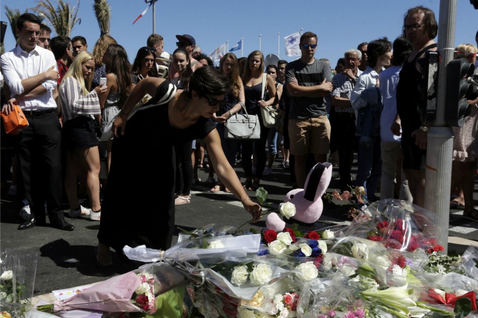 Una mujer deposita flores en honor a las víctimas de del atentado, en inmediaciones del paseo marítimo de Niza. / EFE