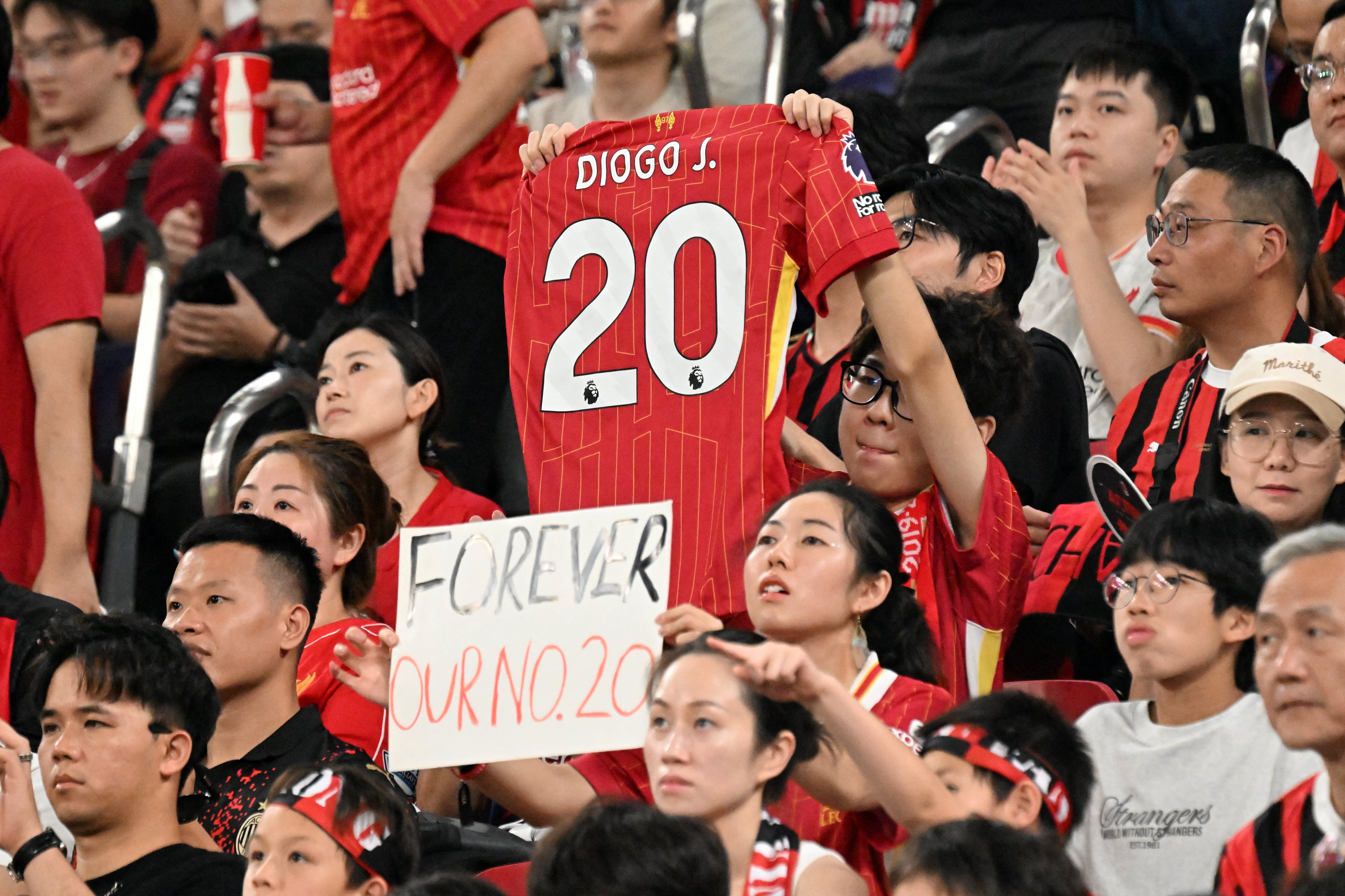 TOPSHOT - Liverpool fans pay tribute to the late Liverpool player Diogo Jota before their friendly exhibition football match against AC Milan at the Kai Tak Stadium in Hong Kong on July 26, 2025. (Photo by Peter PARKS / AFP)