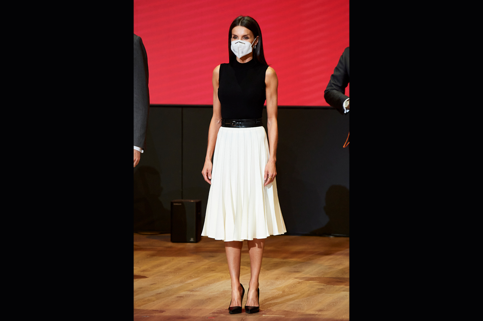 .Letizia ha elegido una camisa negra y pantalón sastre blanco. La chaqueta de rayas grises, negra, cobre y marsala, con diseños étnicos de la marca Uterqüe que combinó con unos tacones rojos de la misma marca.