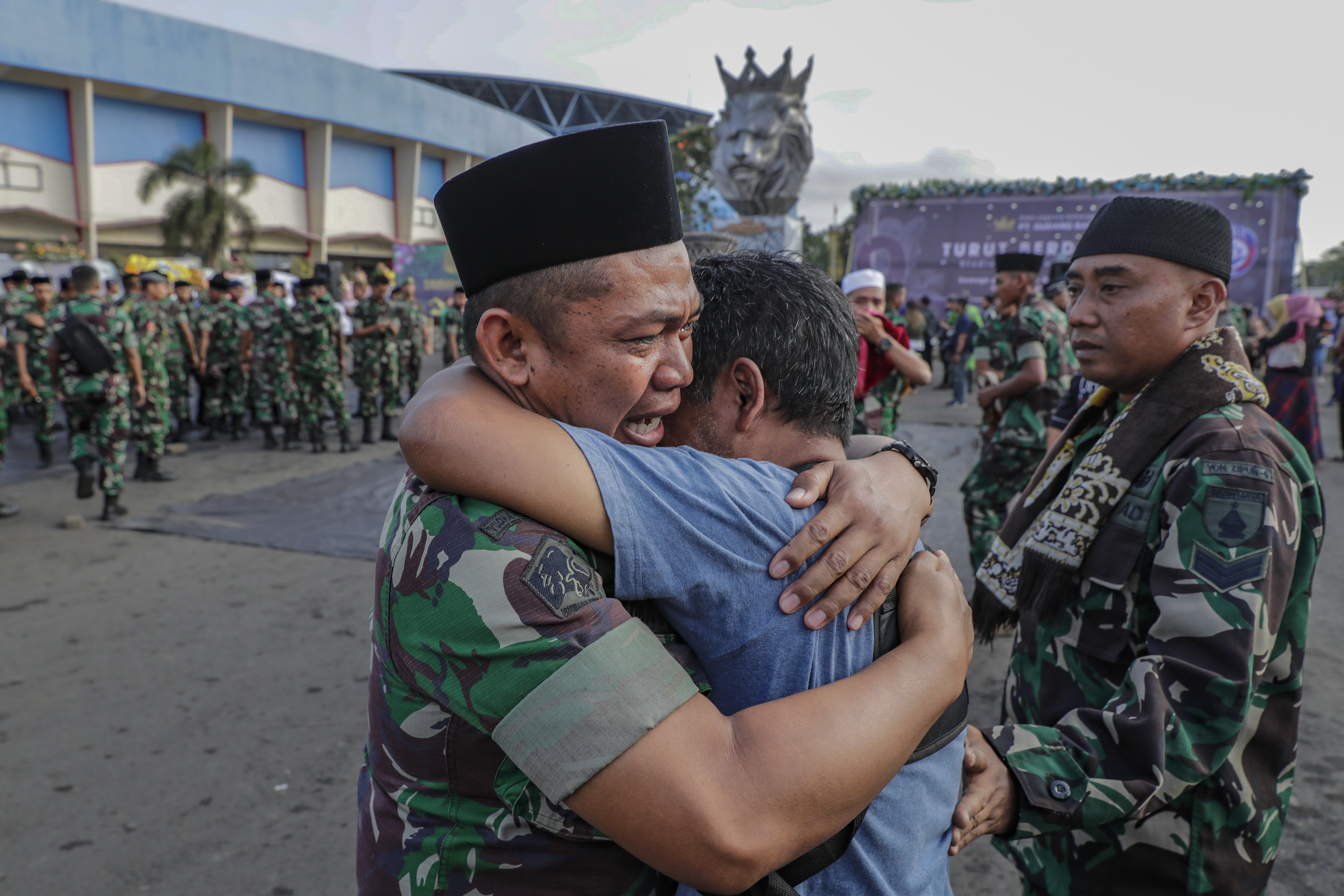 Malang (Indonesia), 04/10/2022.- A soldier and a civilian hug each other during a mass prayer for the victims of a deadly stampede, outside Kanjuruhan Stadium in Malang, East Java, 04 October 2022. According to Indonesia's Coordinating Minister for Political, Legal and Security Affairs Mahfud MD, the government formed an independent investigation team after at least 125 people died during a riot and stampede following a soccer match between Arema FC and Persebaya Surabaya in East Java on 01 October 2022. EFE/EPA/MAST IRHAM