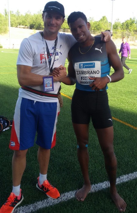 Anthony Zambrano, con uniforme de entrenamiento: esqueleto azul y panatalonteta negra ajustada; posa con el médico italiano Salvio Di Guida, en un estadio.