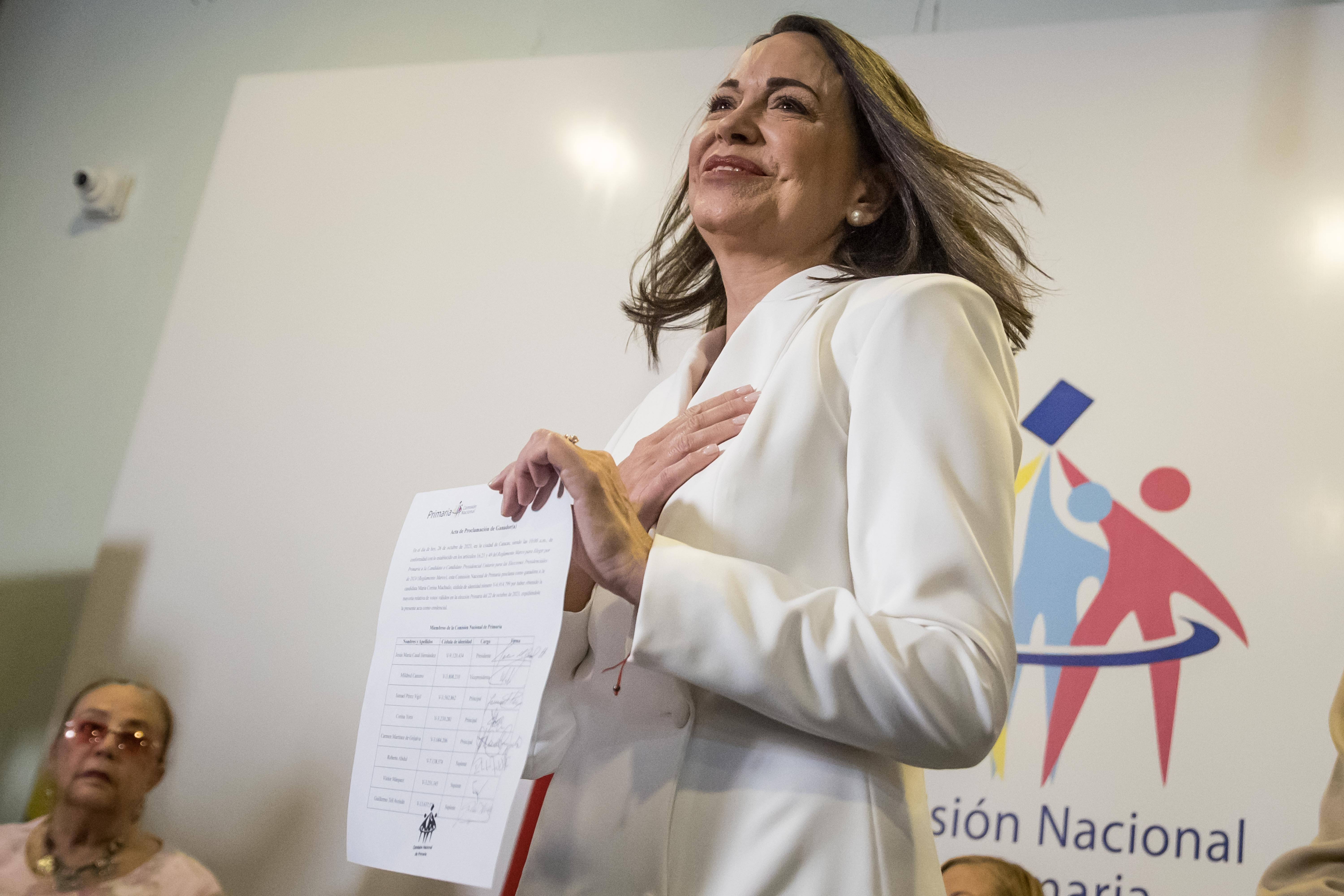 AME9309. BOGOTÁ (COLOMBIA), 21/10/2024.- Fotografía de archivo del 26 de octubre de 2023 donde se observa a la líder de oposición, María Corina Machado, recibiendo el documento que le decretaba ganadora de las elecciones primarias de la Plataforma Unitaria Democrática (PUD), en Caracas (Venezuela). María Corina Machado cumple su primer año como líder de la oposición en Venezuela, donde ha conducido las acciones de la principal coalición antichavista frente a multitud de obstáculos y ataques, la mayoría derribados con astucia y con estrategias que pocos vieron venir, sobre todo por el talante político demostrado antes de llegar a la cúspide. EFE/ Miguel Gutiérrez ARCHIVO