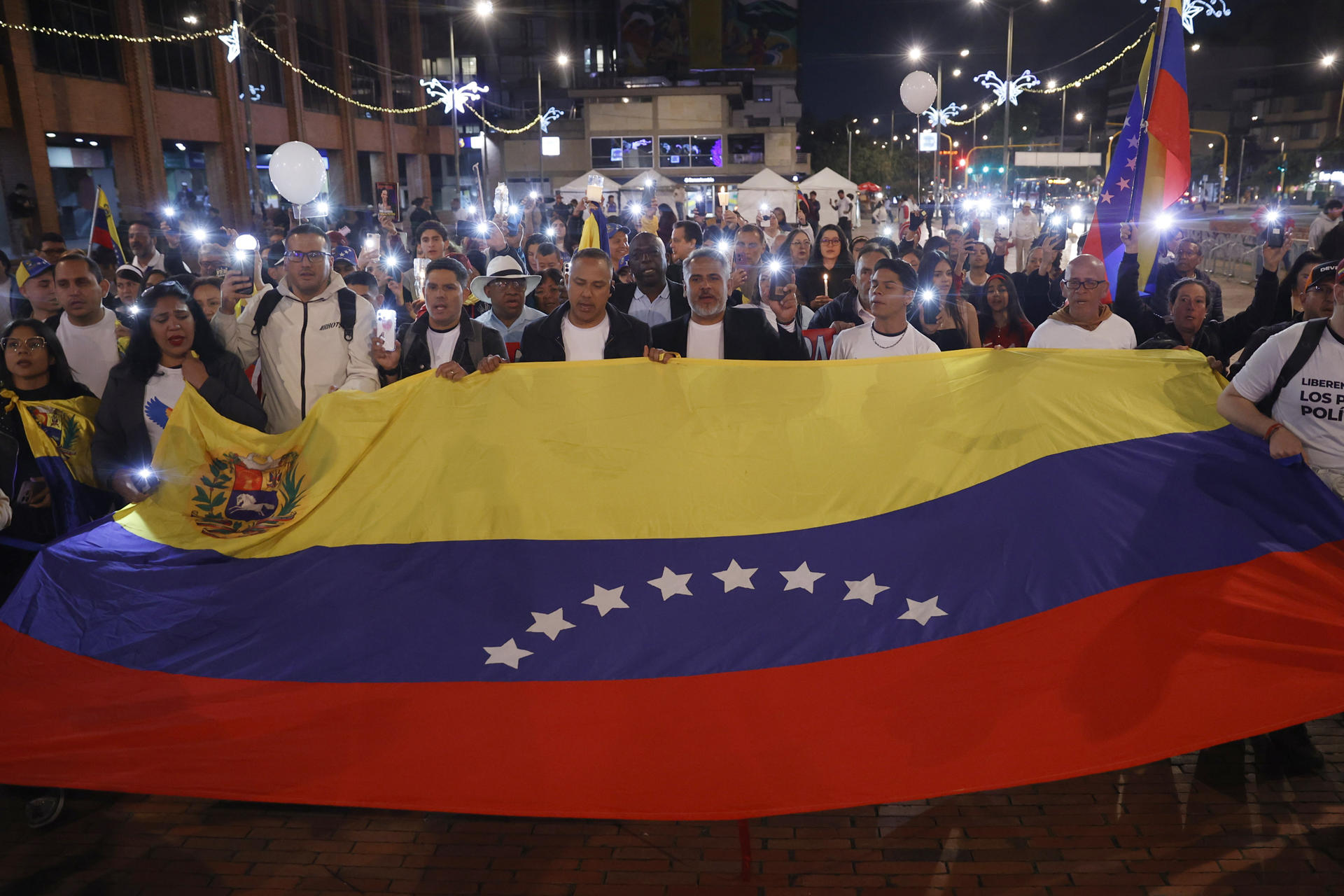 AME6464. BOGOTÁ (COLOMBIA), 06/12/2025.- Personas sostienen una bandera durante la marcha "por la paz y la libertad" en Venezuela, en conmemoración al Nobel de la Paz el 10 de diciembre a la líder antichavista María Corina Machado, este sábado, en Bogotá (Colombia). EFE/ Mauricio Dueñas Castañeda