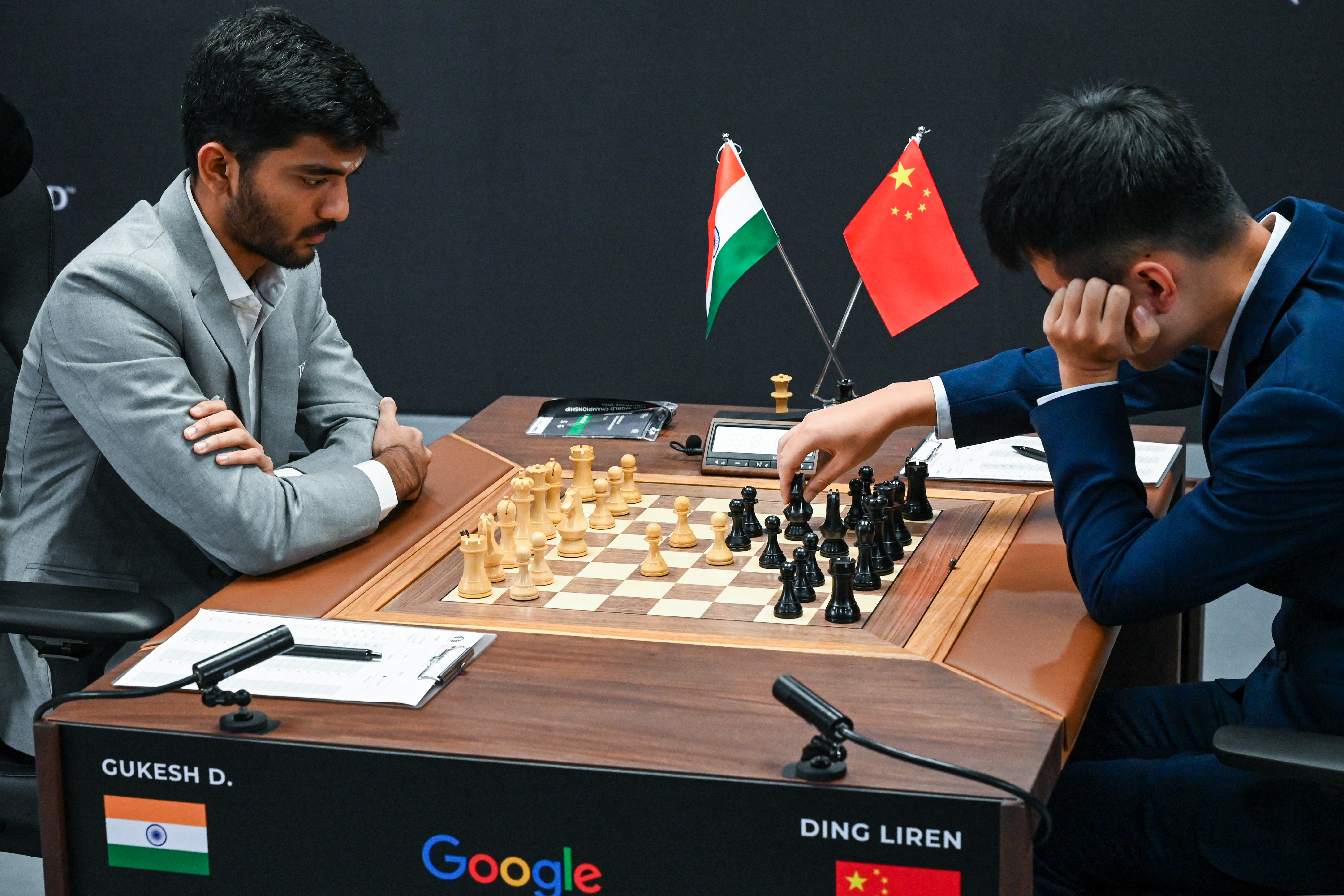 China’s chess grandmaster Ding Liren (R) and India’s chess grandmaster Gukesh Dommaraju (L) compete during the start of the FIDE World Chess Championship in Singapore on November 25, 2024. (Photo by Roslan RAHMAN / AFP)