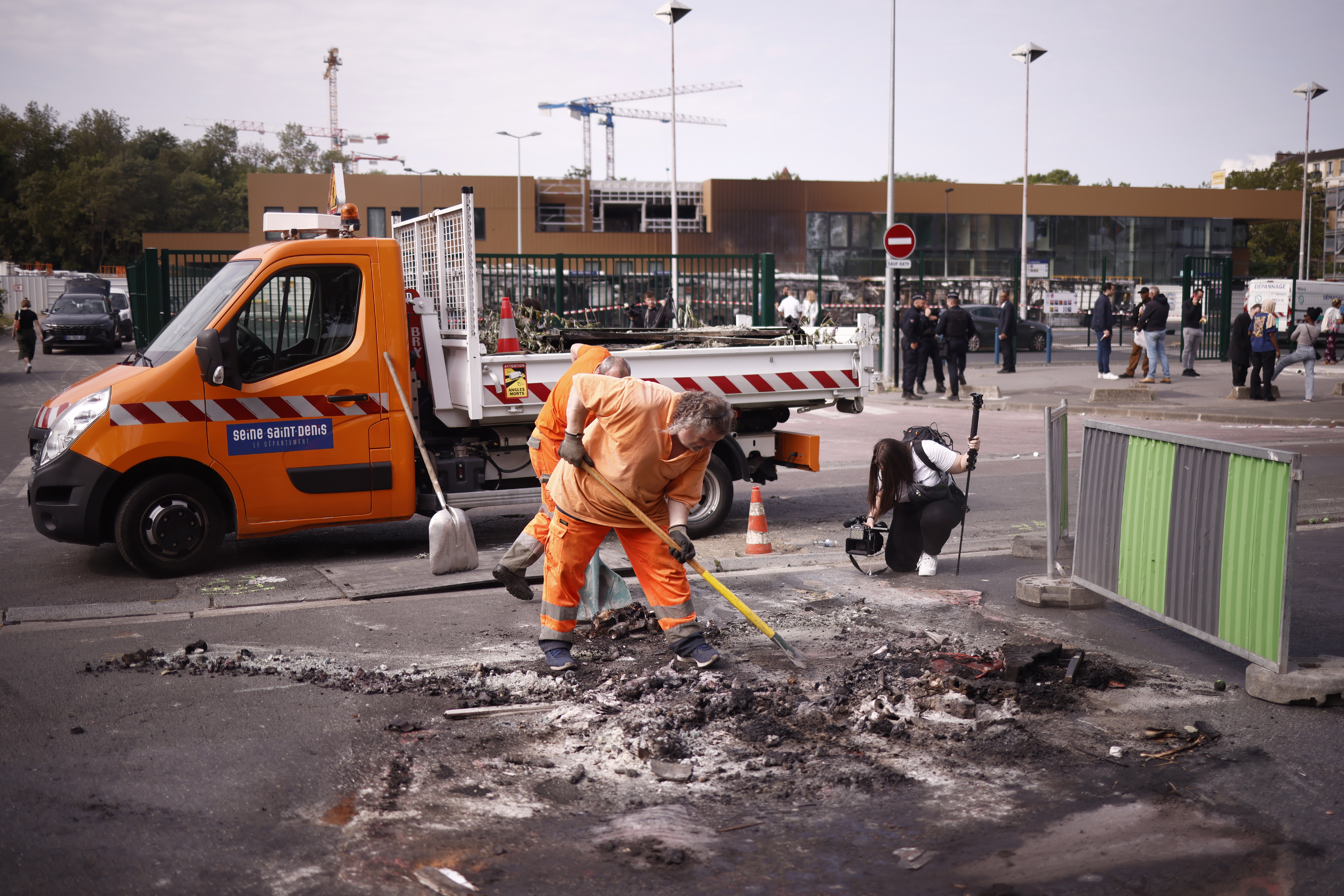 Aubervilliers (France), 30/06/2023.- Road workers clean up after buses were burned overnight at a public transport site in Aubervilliers, near Paris, France, 30 June 2023. Violence broke out all over France after police fatally shot Nael, a 17-year-old, during a traffic stop in Nanterre on 27 June. (Disturbios, Francia) EFE/EPA/YOAN VALAT