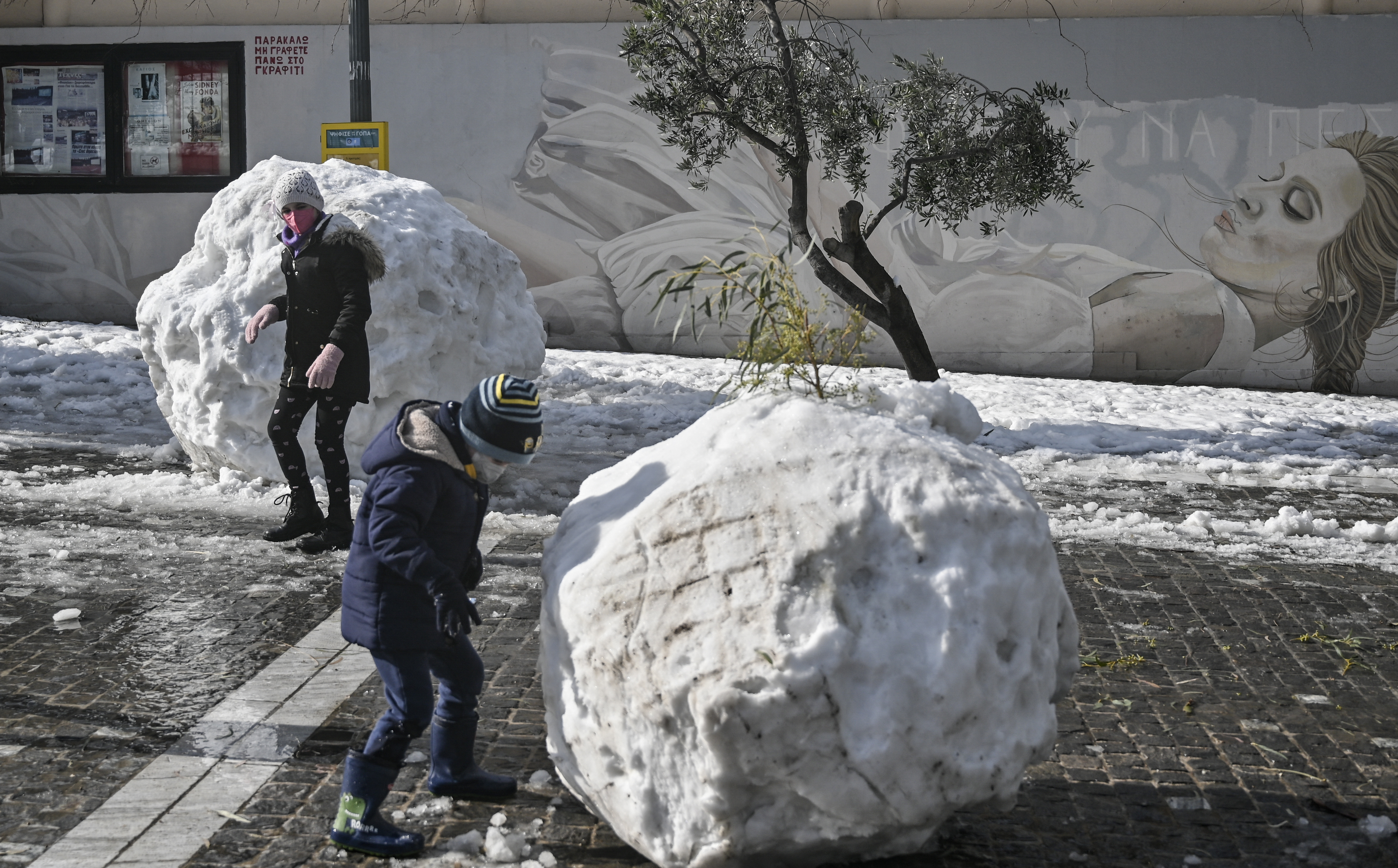 Niños juegan con la nieve, que en otras partes de la ciudad afectó el tráfico.