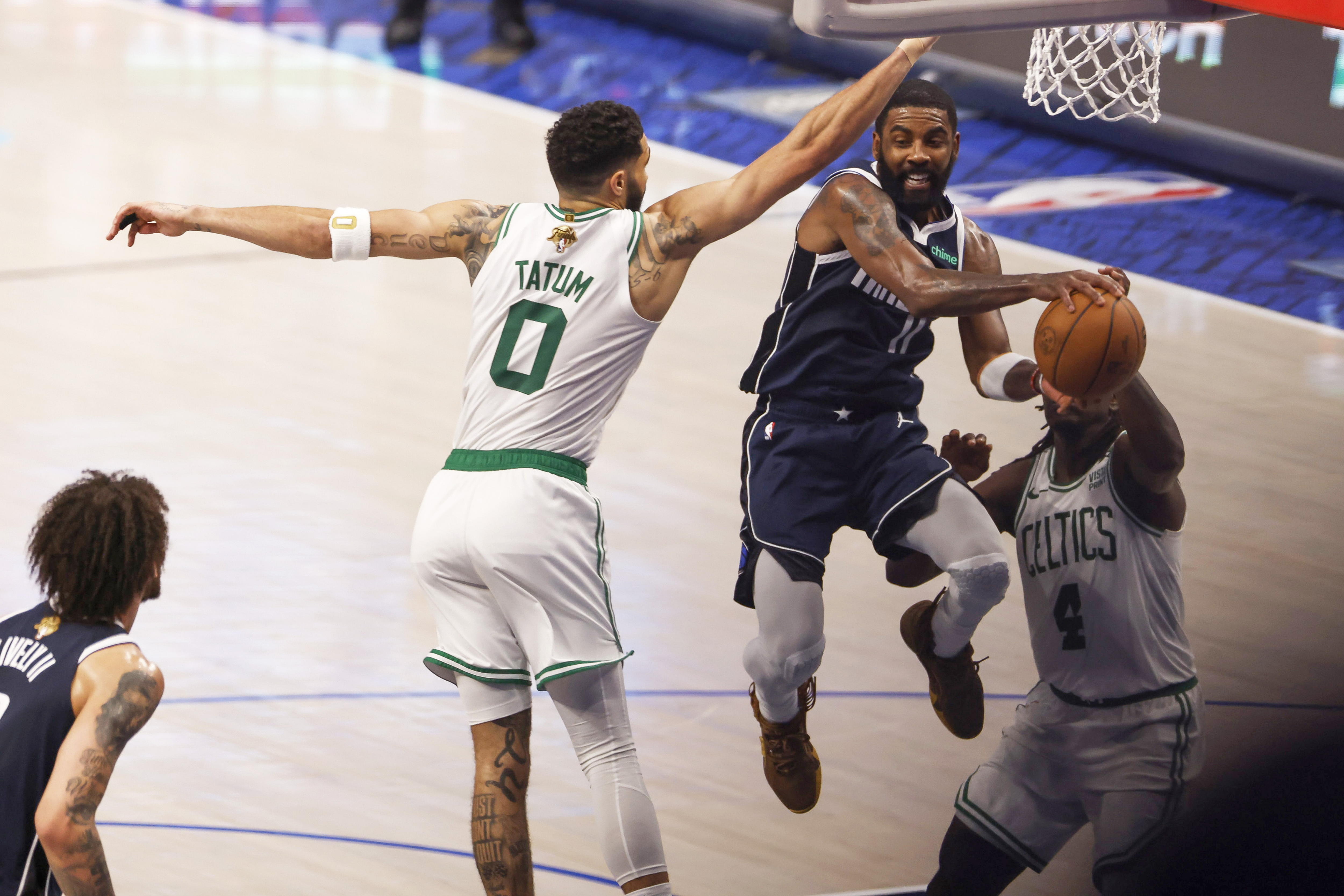 Arlington (United States), 13/06/2024.- Dallas Mavericks guard Kyrie Irving passes the ball between Boston Celtics forward Jayson Tatum (L) and guard Jrue Holiday during the second half of the NBA Finals game three in Arlington, Texas, USA, 12 June 2024. (Baloncesto) EFE/EPA/ADAM DAVIS SHUTTERSTOCK OUT