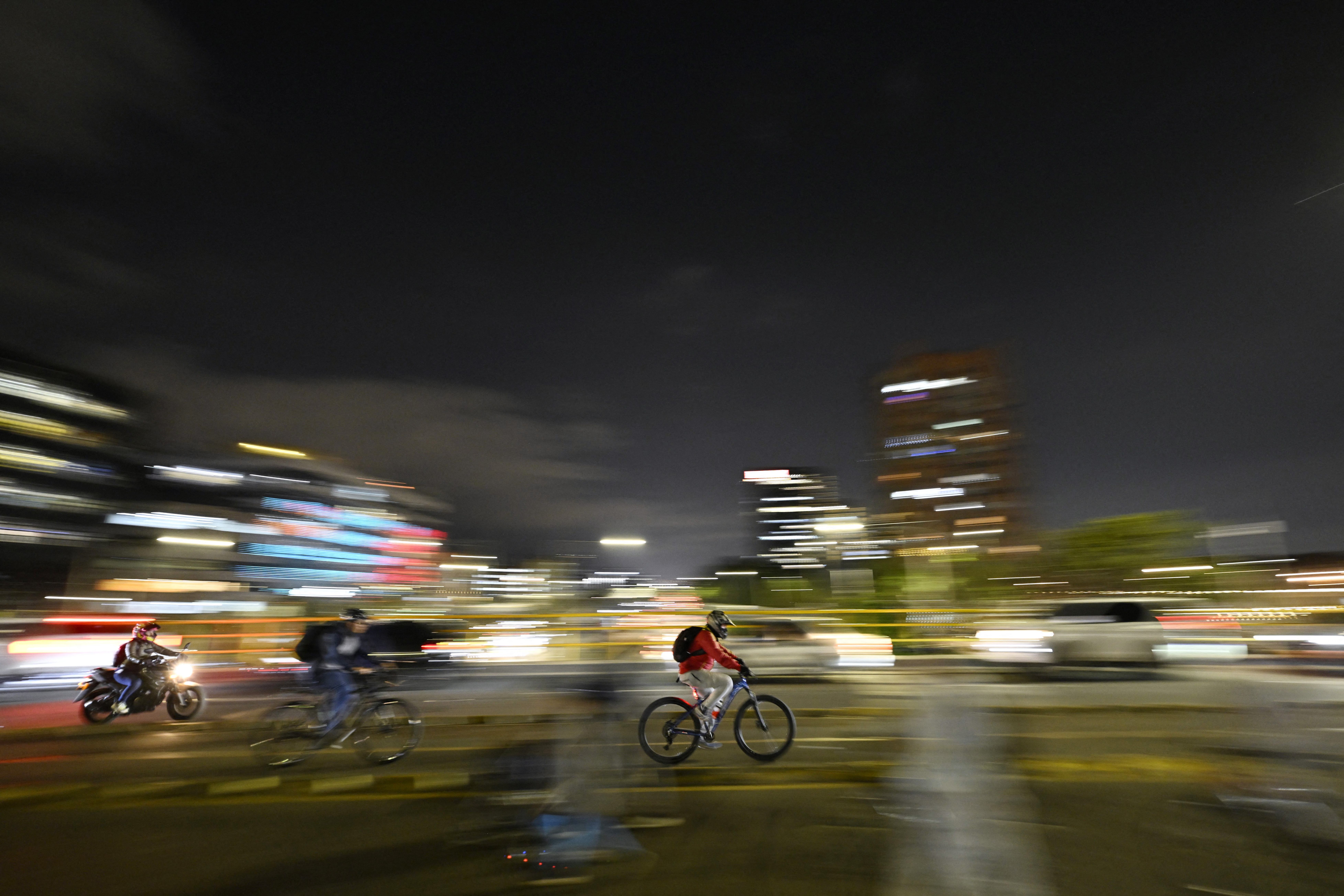 Cyclists ride on a bike path during a weekly car-free day in Bogota on December 12, 2024.