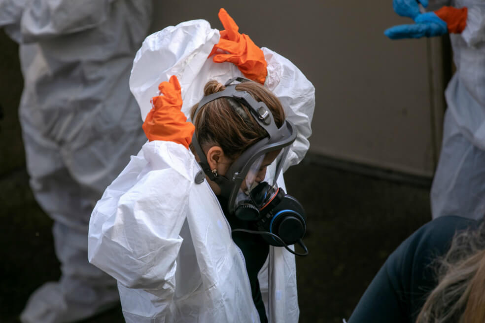 Un equipo de limpieza se quita la ropa protectora después de salir del Life Care Center el 11 de marzo de 2020 en Kirkland, Washington. La mayoría de las muertes por coronavirus en el estado de Washington se han relacionado con el hogar de ancianos. / AFP