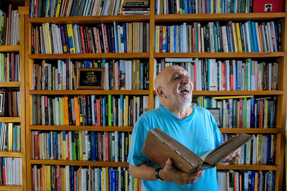 Juan Gossaín en su biblioteca personal. Foto: Manuel Pedraza para los autores“Cuando vimos que le publicaban y le publicaban, pensamos: Juan se quedará mucho tiempo en la Capital”, sostiene Janeth, la hermana con la que más se entendía en asuntos de juego y travesuras, por la cercanía generacional. Y se quedó alrededor de 18 meses en El Espectador, durante los cuales escribió alrededor de 900 páginas de crónicas, según se puede contar en los archivos del periódico.