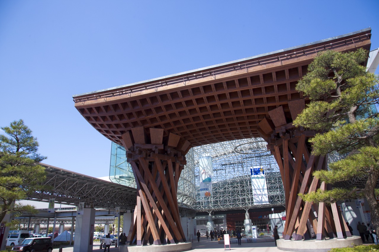 La Kanazawa Station es una de las estaciones más sorprendentes de Japón por su fusión entre tradición y modernidad. Inaugurada en 1898 y renovada en 2005 bajo el diseño de Ryuzo Shirae, destaca por su gran cúpula de vidrio “Motenashi Dome” y la imponente puerta de madera Tsuzumi-mon, inspirada en un tambor del teatro Noh. Más que un punto de tránsito, funciona como un espacio cultural y comercial que da la bienvenida a los viajeros.