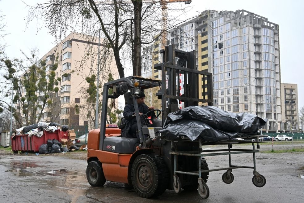 Un hombre conduce una carretilla con cuerpos exhumados para llevarlos a la morgue en Bucha, al noroeste de Kiev.