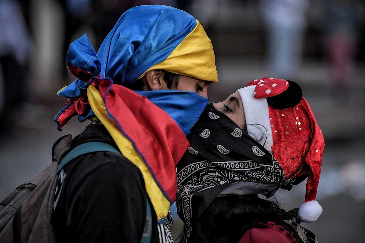 Feliz navidad, una pareja se besa durante una marcha en Bogotá.