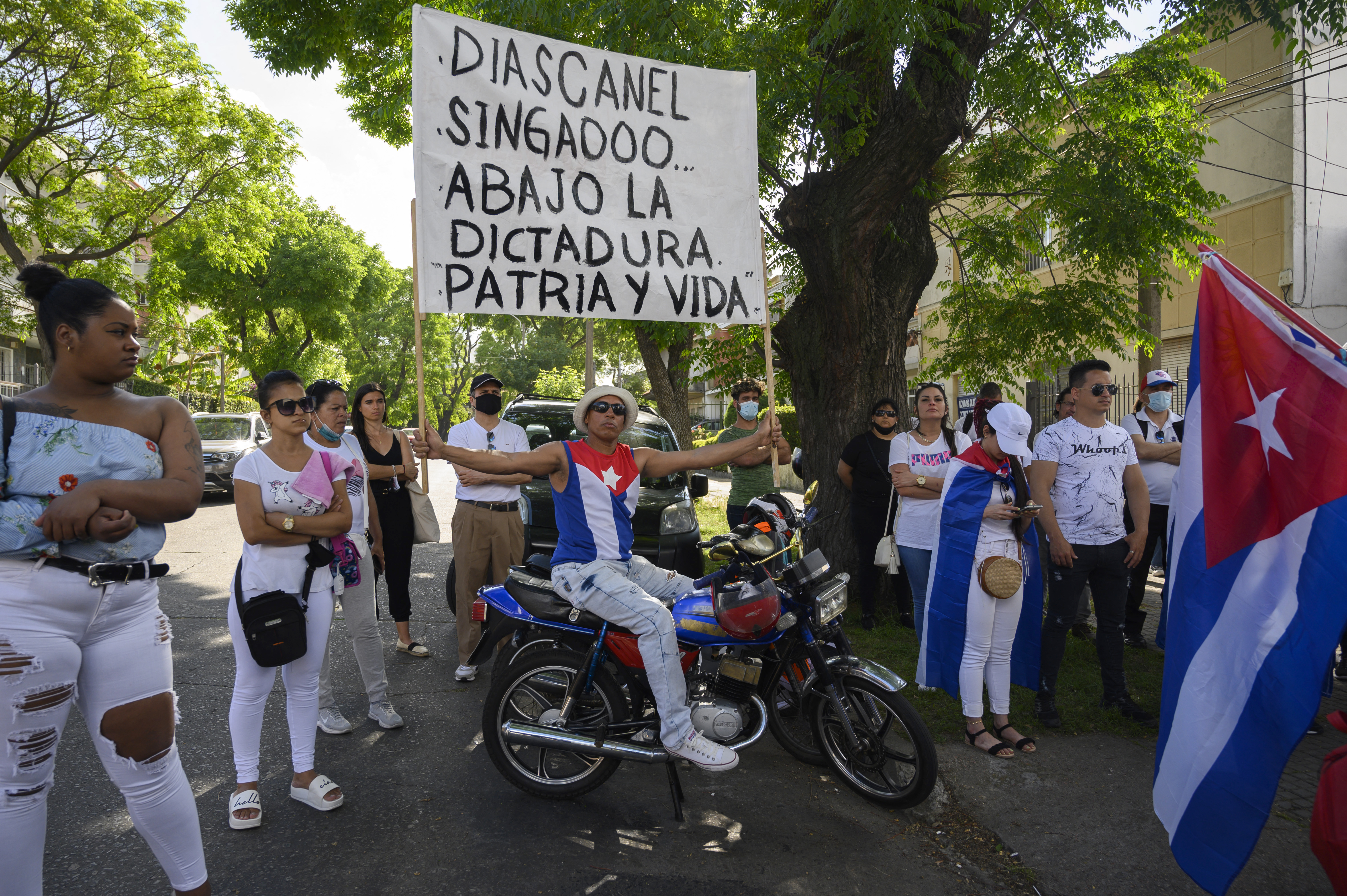 A group of Cubans living in Uruguay demonstrate in support of the Cuban opposition, in front of Cuba's embassy in Montevideo on November 15, 2021. - The Cuban opposition has said it will take to the streets as planned on Monday to demand the release of political prisoners, despite authorities banning the demonstration and preventing its organizers leaving their homes the day before. News of the "15N" (November 15) gathering in Havana and six provinces has spread rapidly on Cuban social media platforms in past weeks, with opposition supporters planning to highlight the continued detention of hundreds of prisoners jailed since history-making protests in July. (Photo by Pablo PORCIUNCULA / AFP)