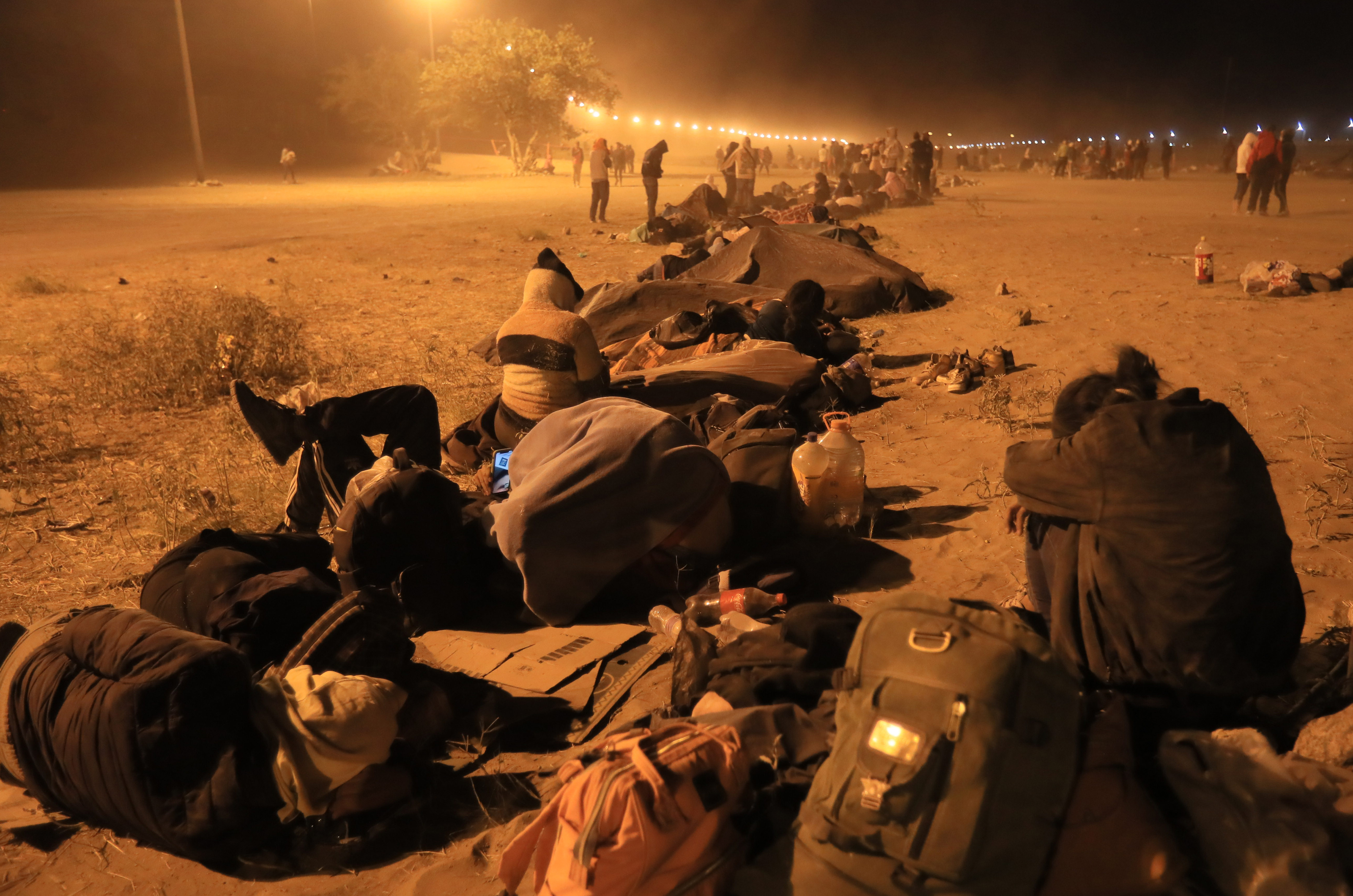 -FOTODELDÍA- MEX4996. CIUDAD JUÁREZ (MÉXICO), 12/05/2023.- Migrantes descansan cerca de la puerta 42 del muro fronterizo en Ciudad Juárez. Elementos de la Guardia Nacional del Estado de Texas, rodean este viernes con barricadas de púas la línea divisoria entre Ciudad Juárez y El Paso ante la culminación del Título 42. Sin embargo, los migrantes esperan que incrementen las citas para solicitar asilo político. EFE/Luis Torres