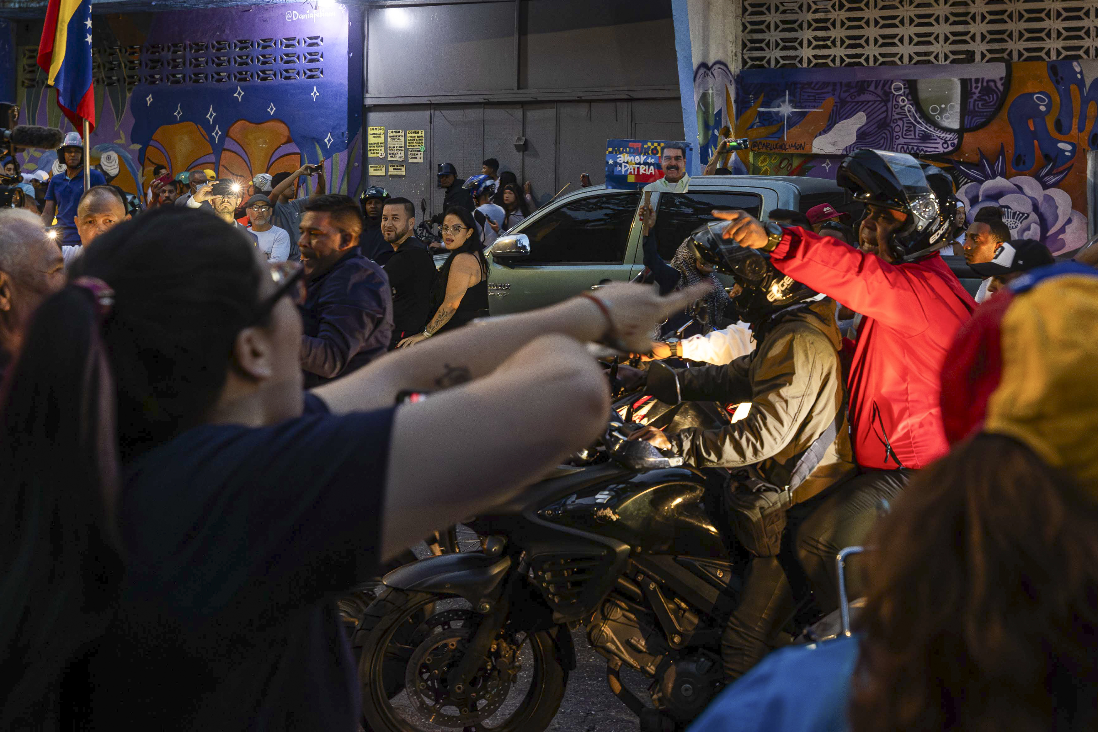 AME6017. CARACAS (VENEZUELA), 28/07/2024.- Seguidores del presidente de Venezuela y candidato a la reelección, Nicolás Maduro, se enfrentan desde una caravana de motocicletas con personas este domingo, en Caracas (Venezuela). Varias decenas de motorizados que se identificaron como chavistas llegaron a un centro de votación en Caracas, donde se encontraban testigos opositores y ciudadanos que esperaban el comienzo del escrutinio de las elecciones presidenciales de este domingo, lo que dio lugar a una confrontación que acabó a golpes, ante la mirada impasible de los policías, que no intervinieron para detener la pelea. EFE/ Henry Chirinos