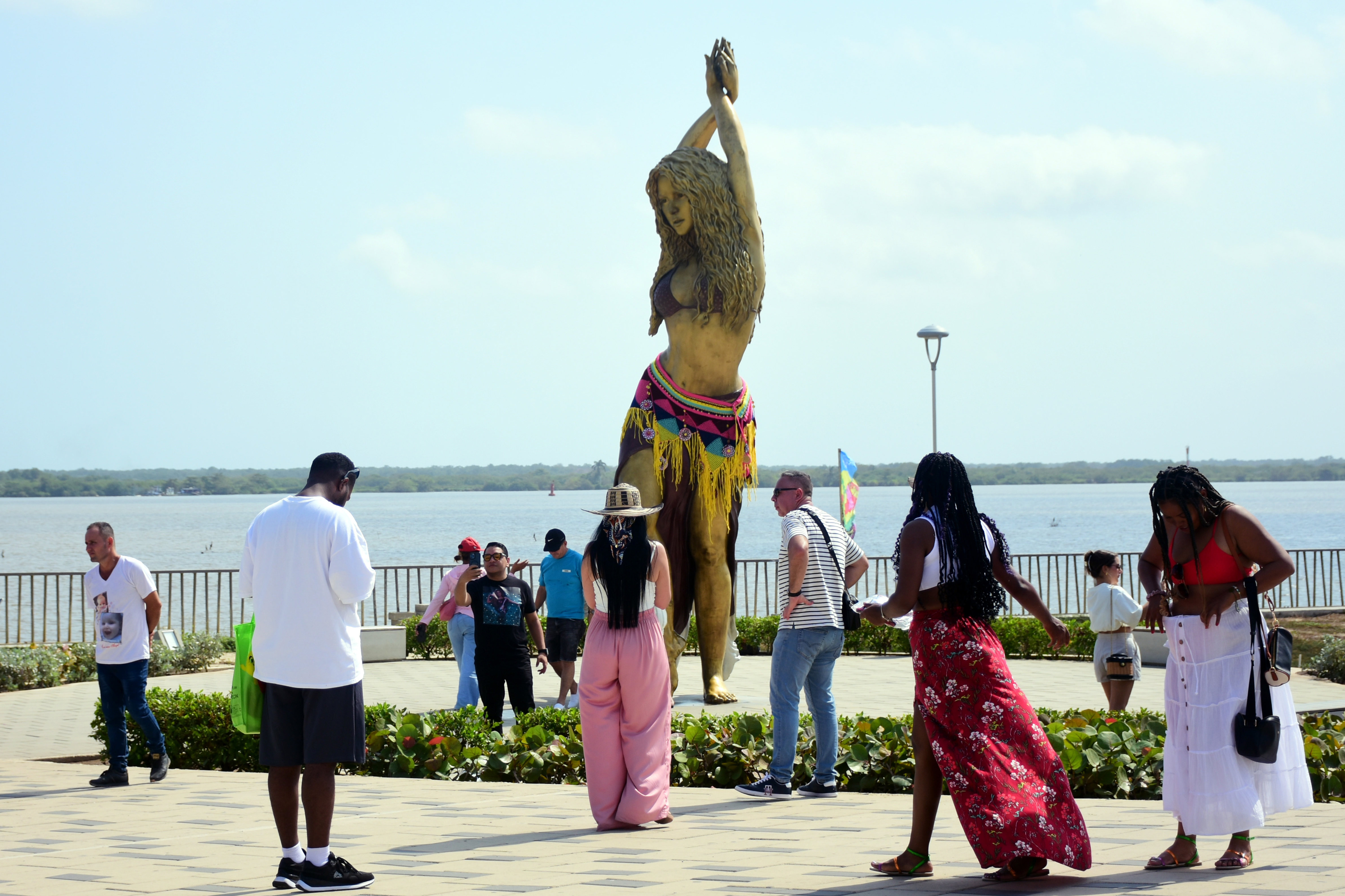 AME1685. BARRANQUILLA (COLOMBIA), 20/02/2025.- Seguidores de la cantante colombiana, Shakira, se toman fotografías con su estatua en el Gran Malecón del Río este jueves, en Barranquilla (Colombia). Los seguidores de Shakira desafiaron el inclemente sol de la caribeña Barranquilla y formaron una larga fila en las afueras del estadio Metropolitano Roberto Meléndez para acceder al primero de los dos conciertos que la artista dará en su ciudad natal como parte de la gira 'Las mujeres ya no lloran'. EFE/ Aleidys Coll