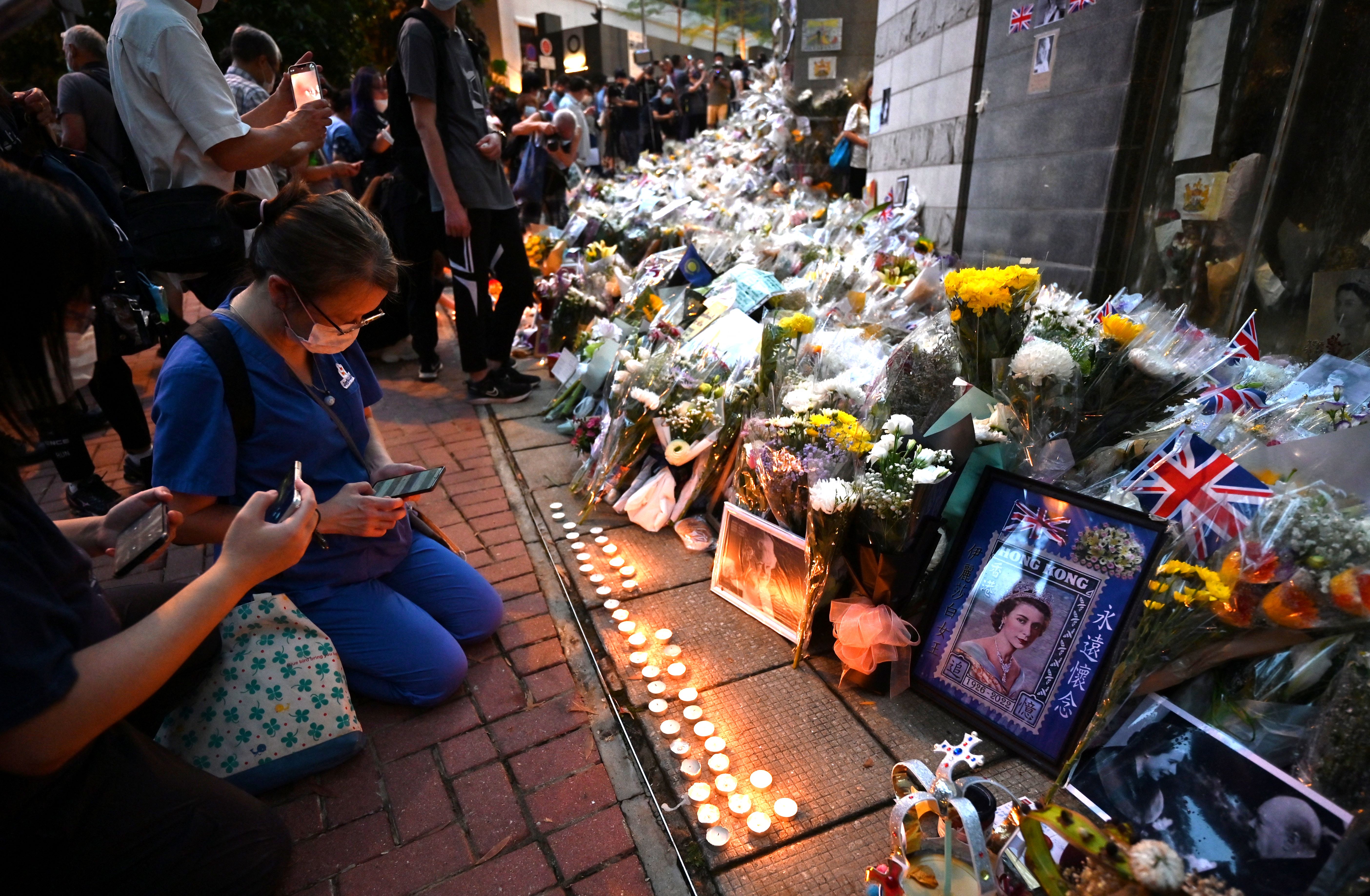 Mientras transcurría el funeral de Isabel II en Londres, algunas personas encendieron velas frente al Consulado Británico en Hong Kong.