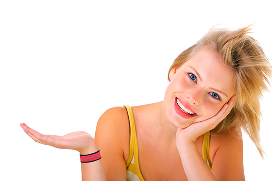 Showing, giving or presenting. Portrait of a beautiful young woman, holding out her hand as displaying something. Ready for you to add text.