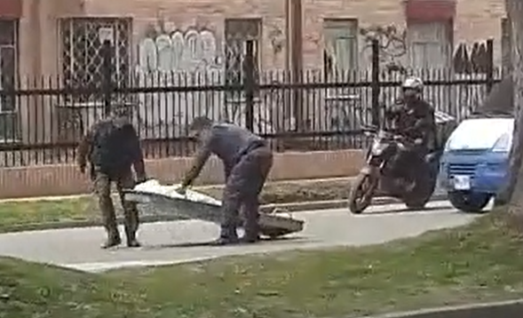 Tirado en el asfalto, funcionarios del CTI dejan caer un cadáver en calle de Suba