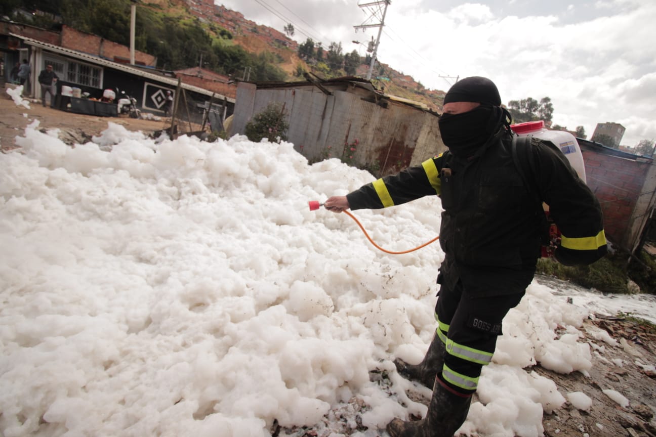 Funcionario de la alcaldía de Soacha, dispersa la espuma tóxica con una maquinaría especial.