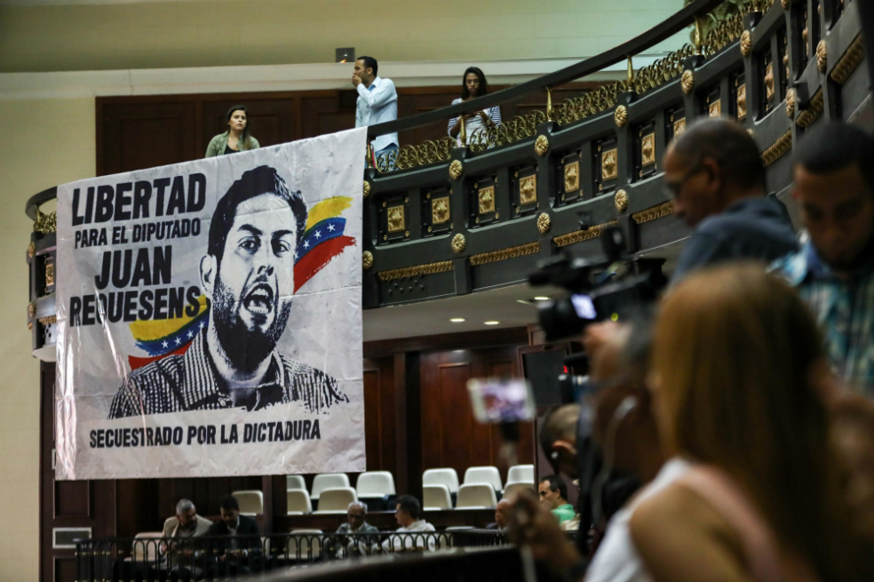 Una pancarta con la imagen del diputado Juan Requesens, quien fue detenido por el Gobierno tras su implicación en el atentado contra el presidente Nicolás Maduro, permanece colgada durante una sesión especial del Parlamento en Caracas (Venezuela). / EFE
