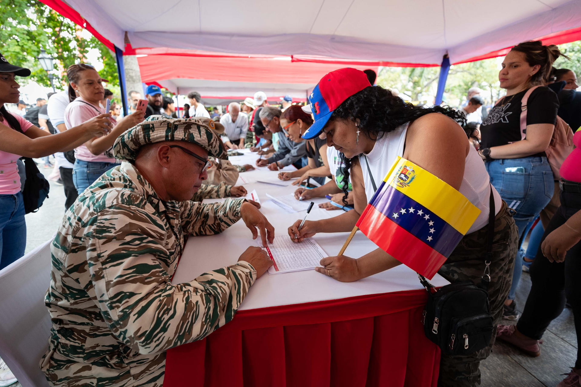 AME3066. CARACAS (VENEZUELA), 23/08/2025.-Personas participan en una jornada de alistamiento de la Milicia Bolivariana de Venezuela, este sábado en Caracas (Venezuela). El ministro venezolano de Defensa, Vladimir Padrino, pidió no "caer en nerviosismo" ante la jornada de alistamiento de las "fuerzas milicianas", convocada por el presidente Nicolás Maduro, en respuesta al patrullaje de buques que planteó EE.UU. en el mar Caribe, cerca del país suramericano, para combatir el narcotráfico. EFE/ Ronald Pena R
