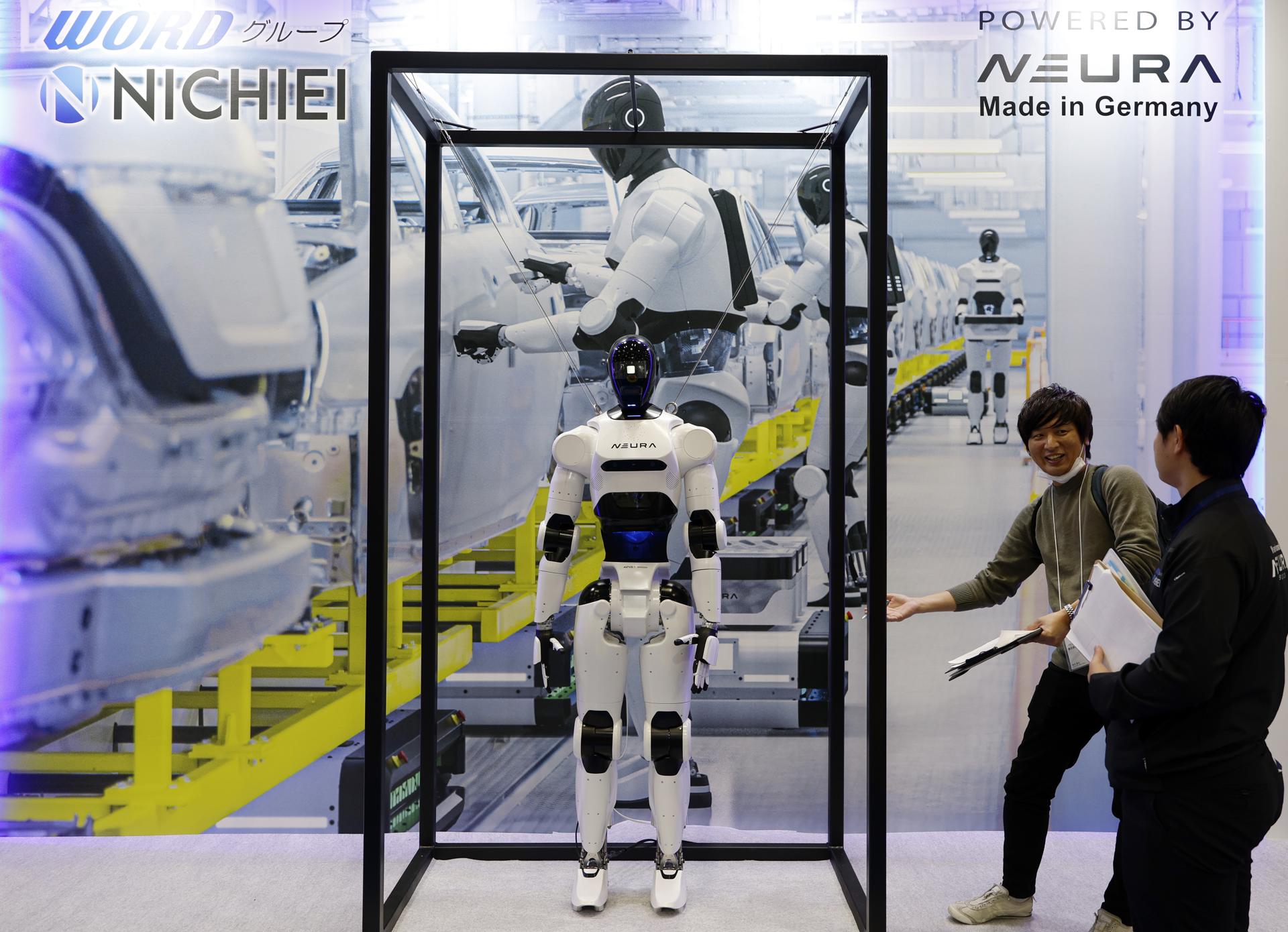 TOKYO (Japan), 03/12/2025.- Visitors stand next to a humanoid robot displayed at the Neura booth during the International Robot Exhibition 2025 (iREX2025) in Tokyo, Japan, 03 December 2025. Held once every two years, the iREX is one of the world’s largest robot trade shows. For the 2025 edition, 673 companies and organizations will be presenting their latest robot technologies until 06 December. (Japón, Tokio) EFE/EPA/FRANCK ROBICHON